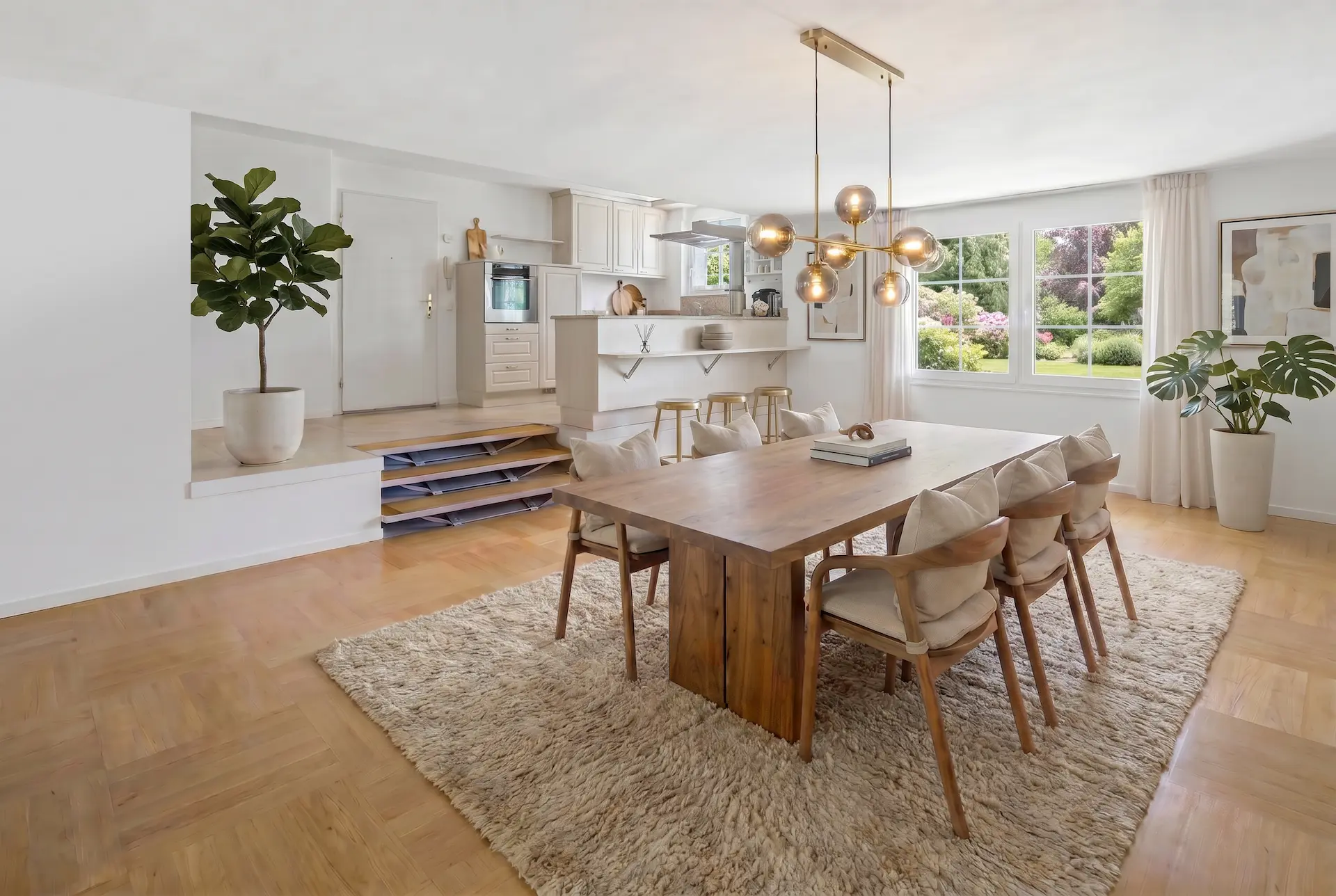 Helles Esszimmer mit heruntergehängter goldener Deckenleuchte im Projekt Küsnacht in Zürich.