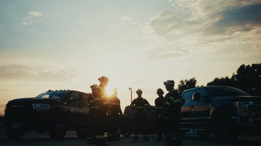 Gold signet ring with engraved emblem resting beside a red wax seal stamped with the same design on a marble surface.