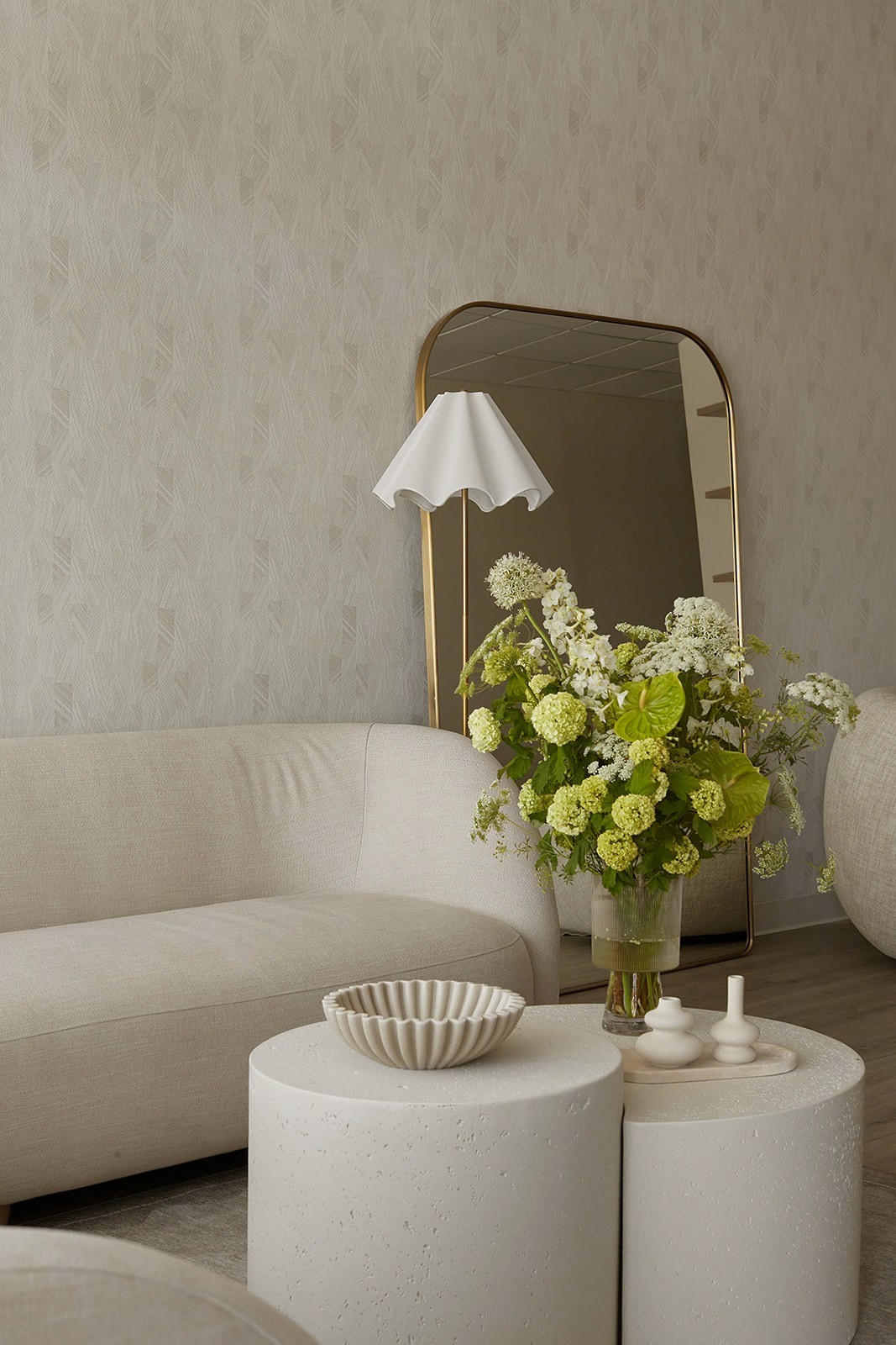 Soft, neutral waiting area at DC Dermatology featuring curved seating, sculptural side tables, and warm, minimal interior finishes.