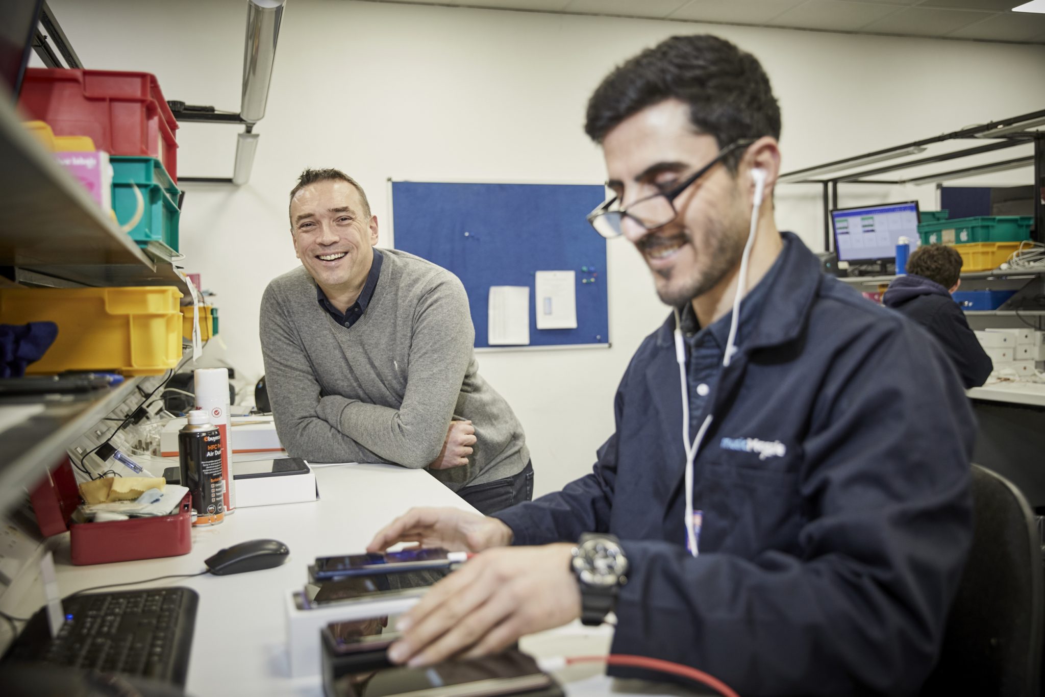 Technicians working on smartphone refurbishment in a repair lab