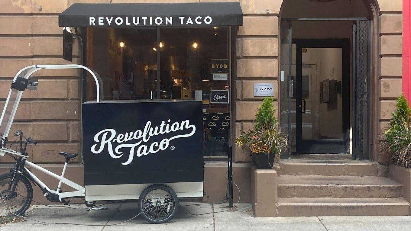 Revolution Taco team posing outside in front of restaurant