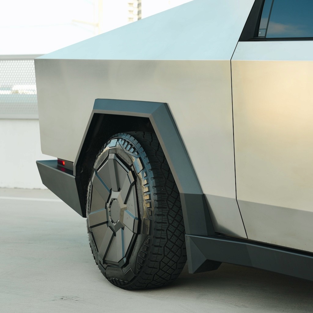 Close-up of the Cybertruck’s rear wheel and geometric fender design, highlighting the armored exoskeleton.