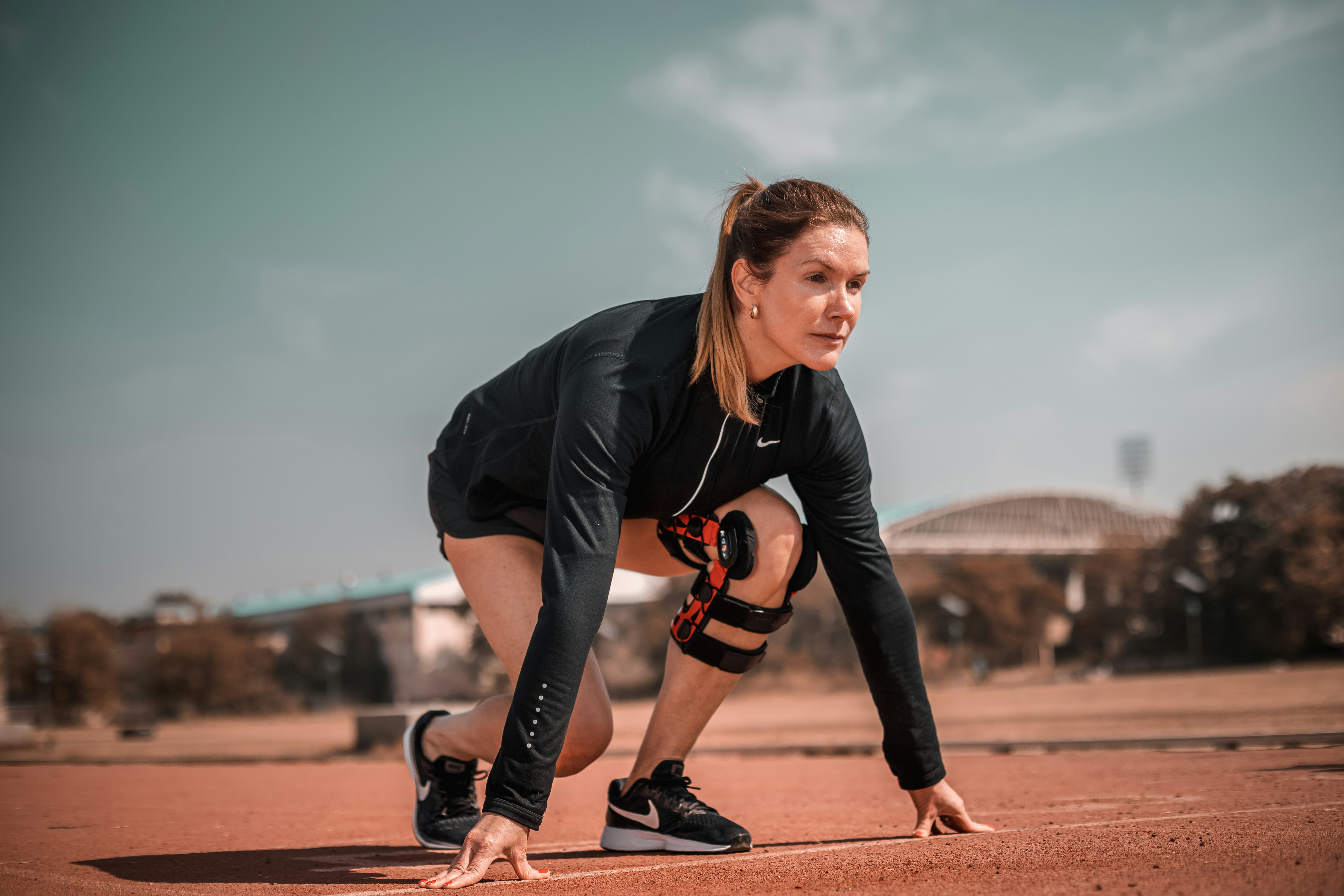 Woman wearing knee brace preparing to return to running after injury
