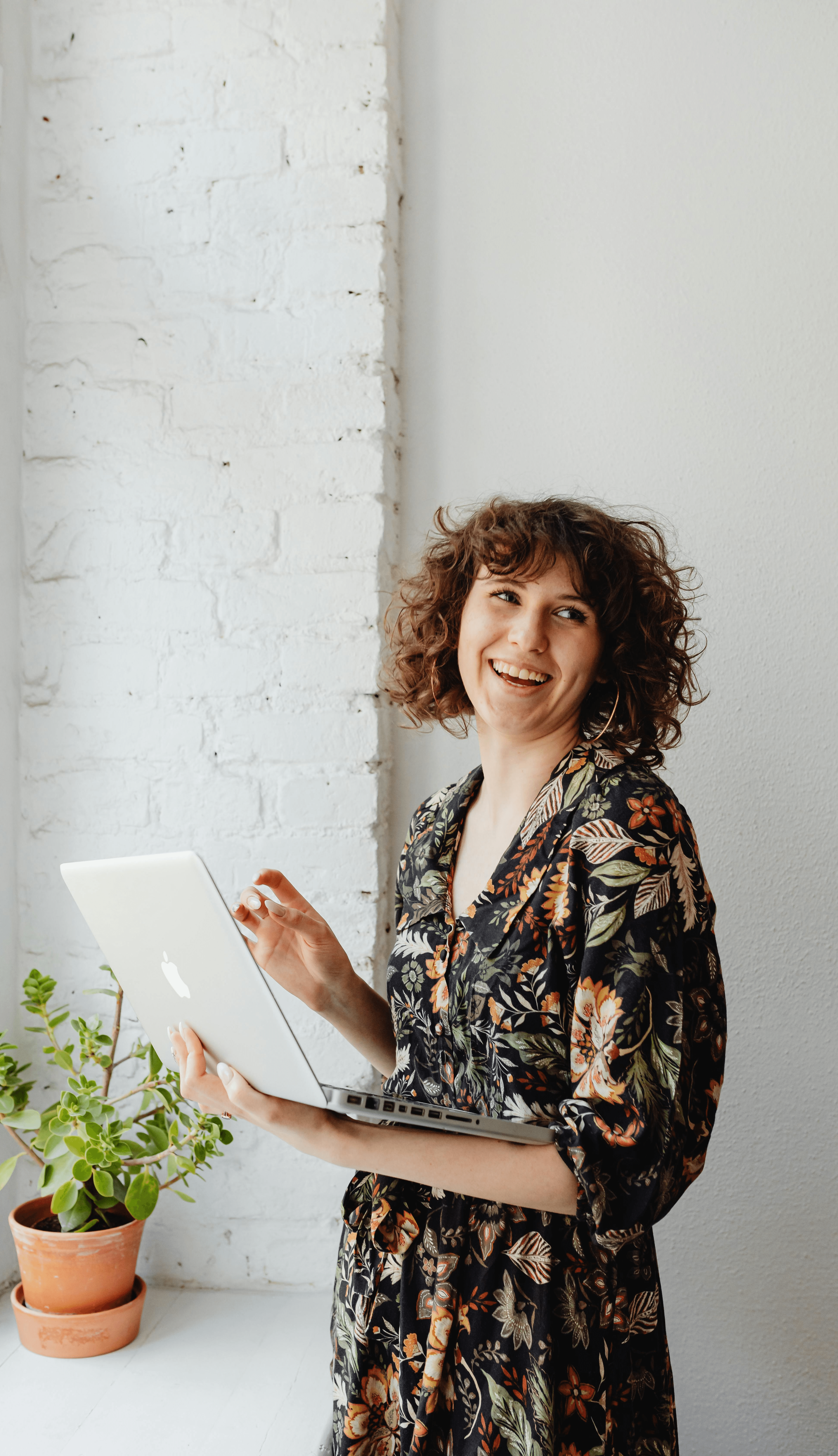 a woman in a yellow shirt leaning on a wall