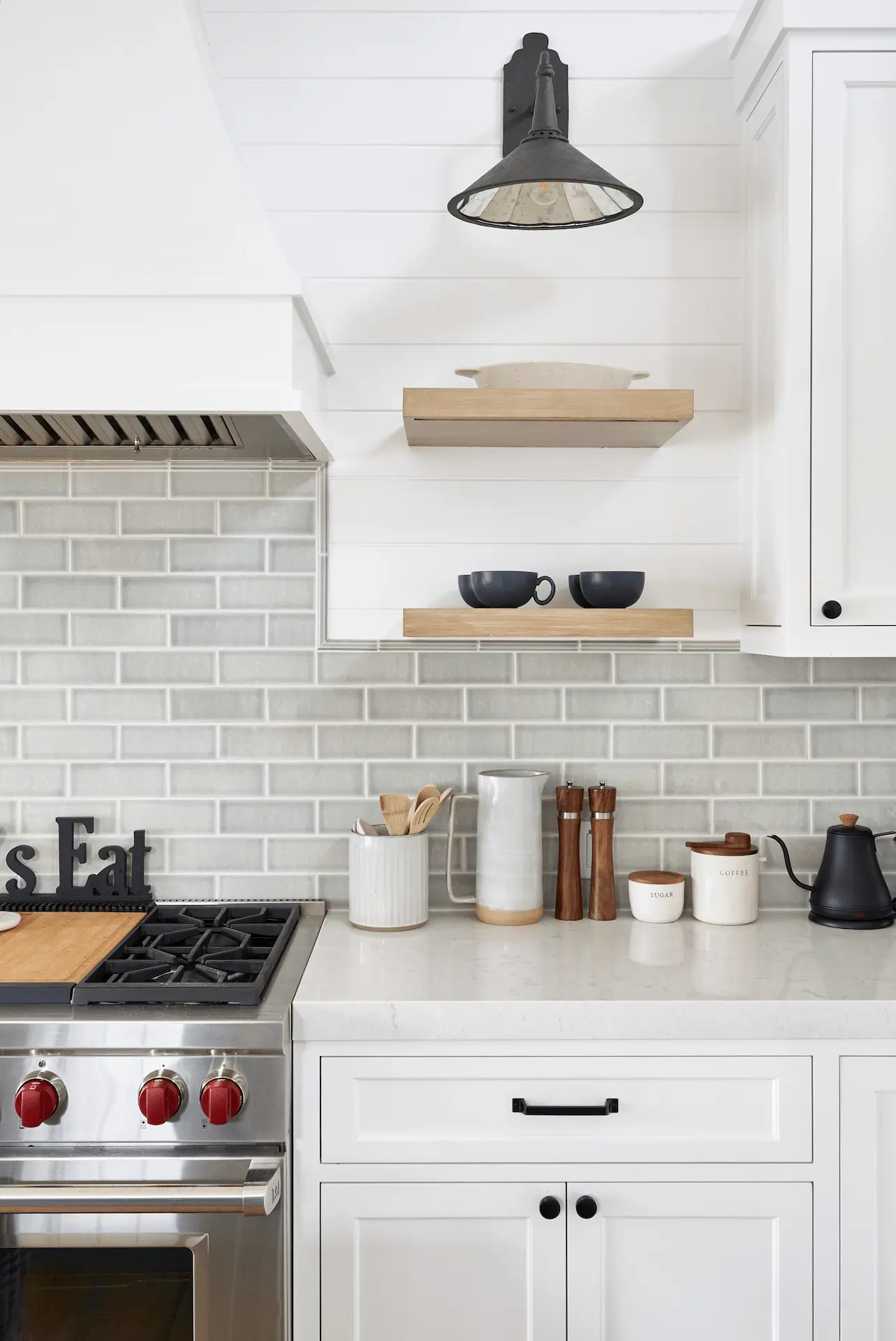 Detailed view of kitchen range with subway tiles and floating shelves in North Tustin Remodel & Addition. Photo by Todd Huge.
