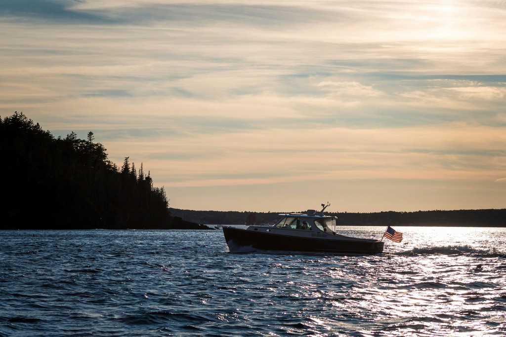 a boat traveling on the water at sunset