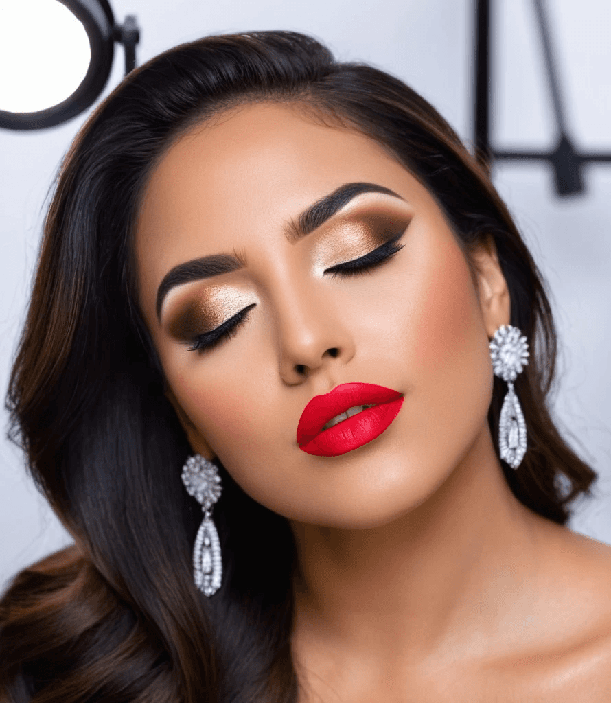 Mujer con maquillaje para sesiones fotográficas, labios rojos, sombras de ojos ahumadas, iluminador brillante, rostro fuertemente contorneado y cejas definidas en Peluquería Carlos y Hugo Spa en Arequipa