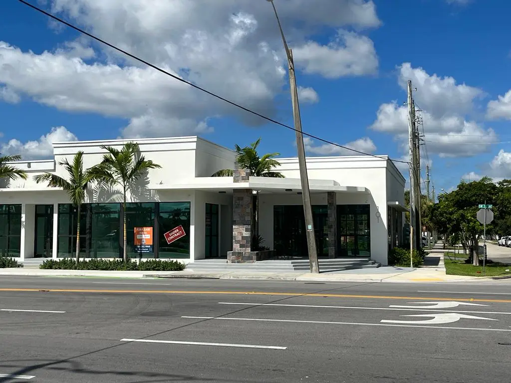Completed commercial retail building with stone columns and floor-to-ceiling windows, Fort Lauderdale
