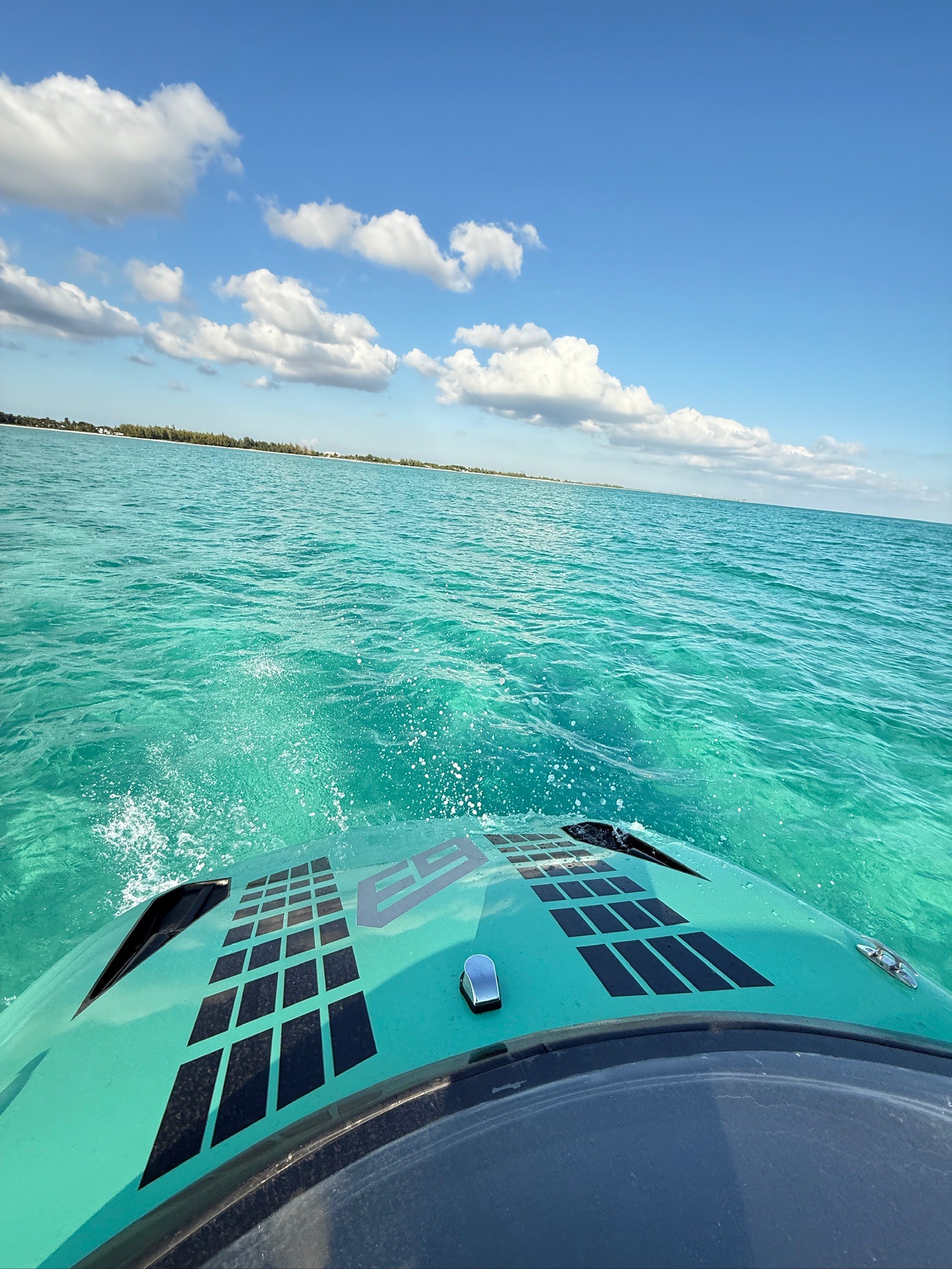 A group of six people gather around a wooden table where an older man in an apron kneads dough