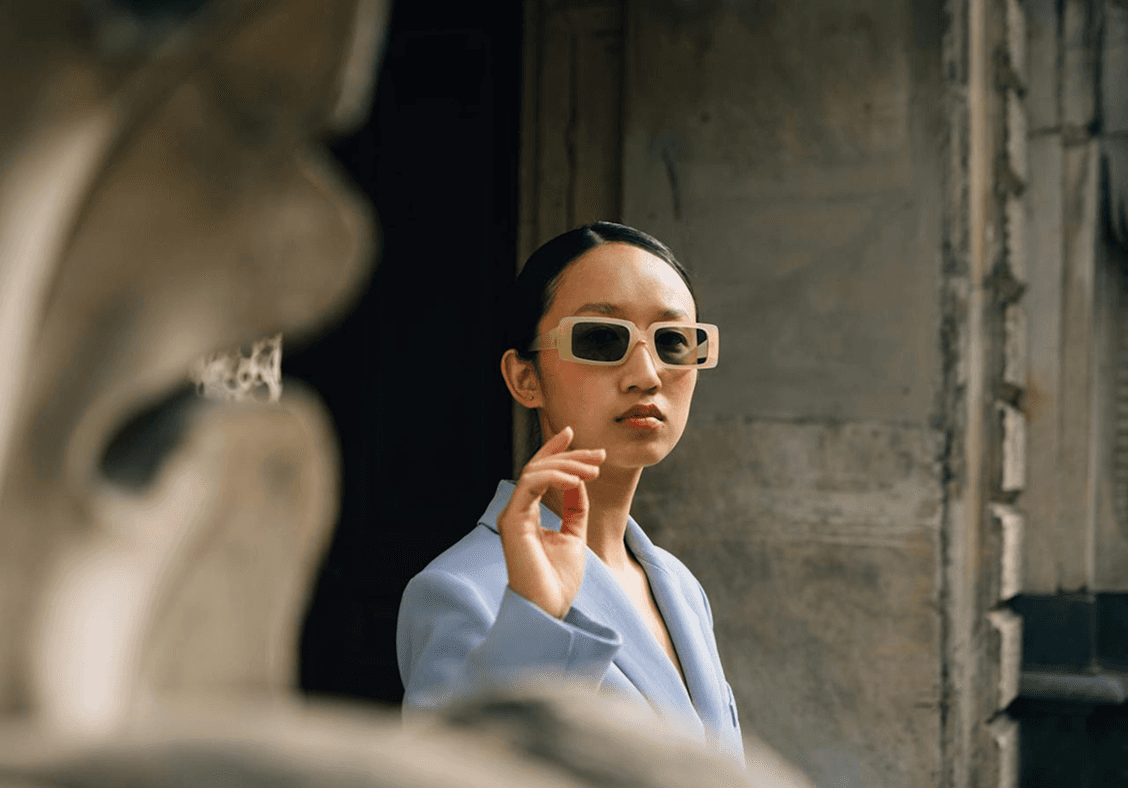 Woman in sunglasses pointing, soft focus.  Outdoor portrait. 