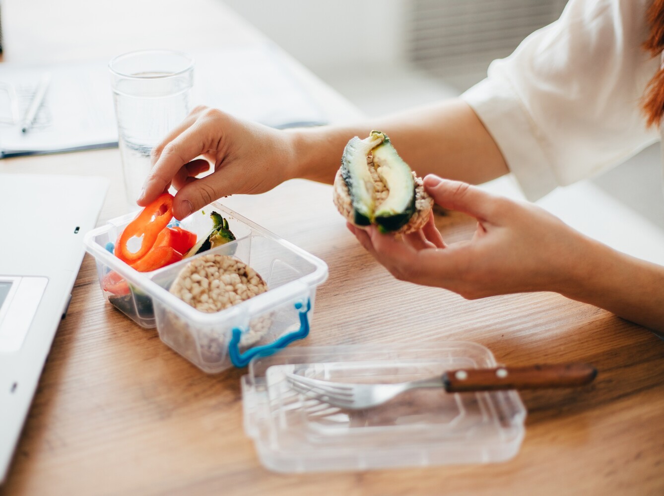 woman eating a healthy pre-prepped snack at the office, showcasing how to lose weight when unable to exercise
