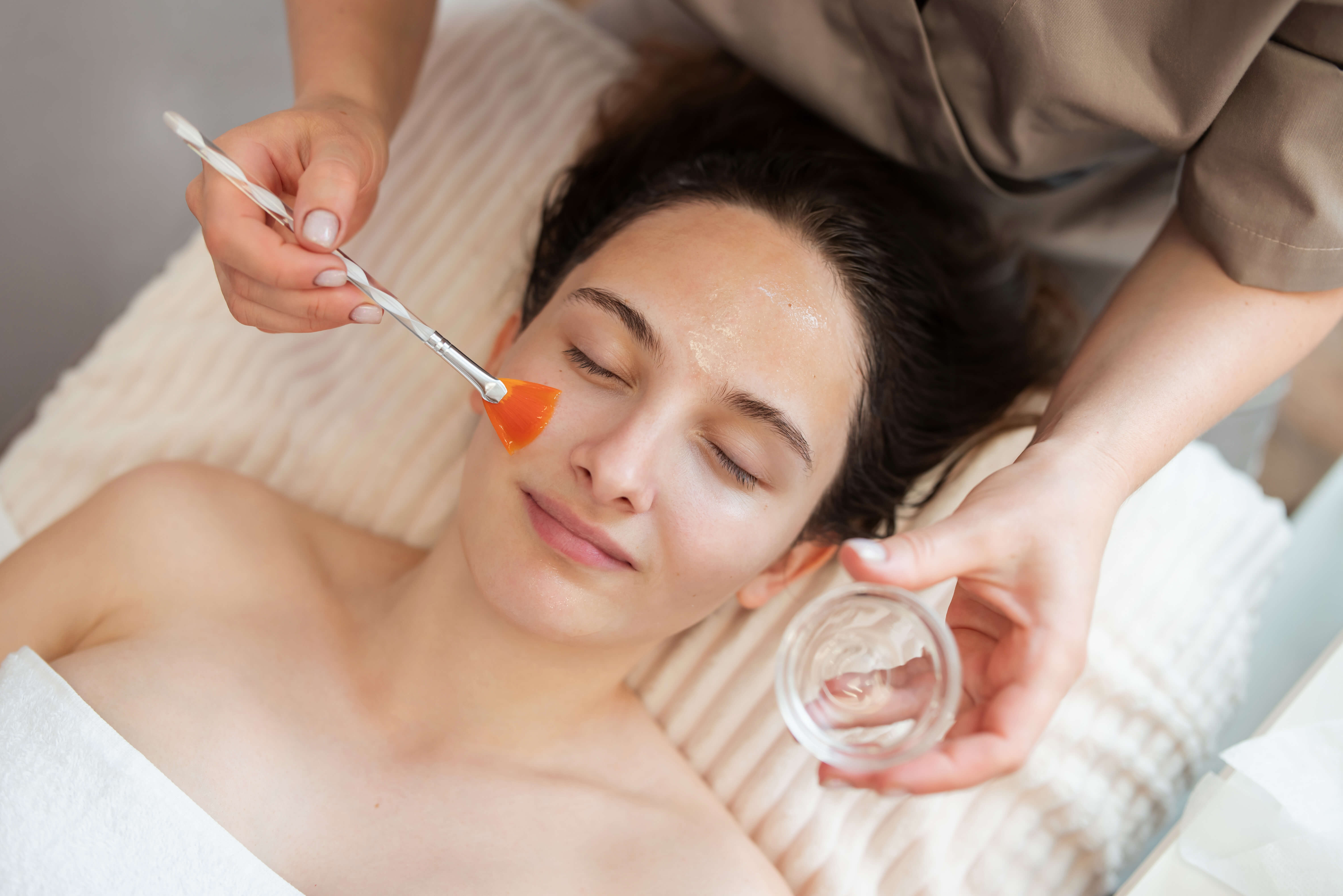 Pielęgnacyjny zabieg Retibooster, nakładanie serum na twarz klientki.