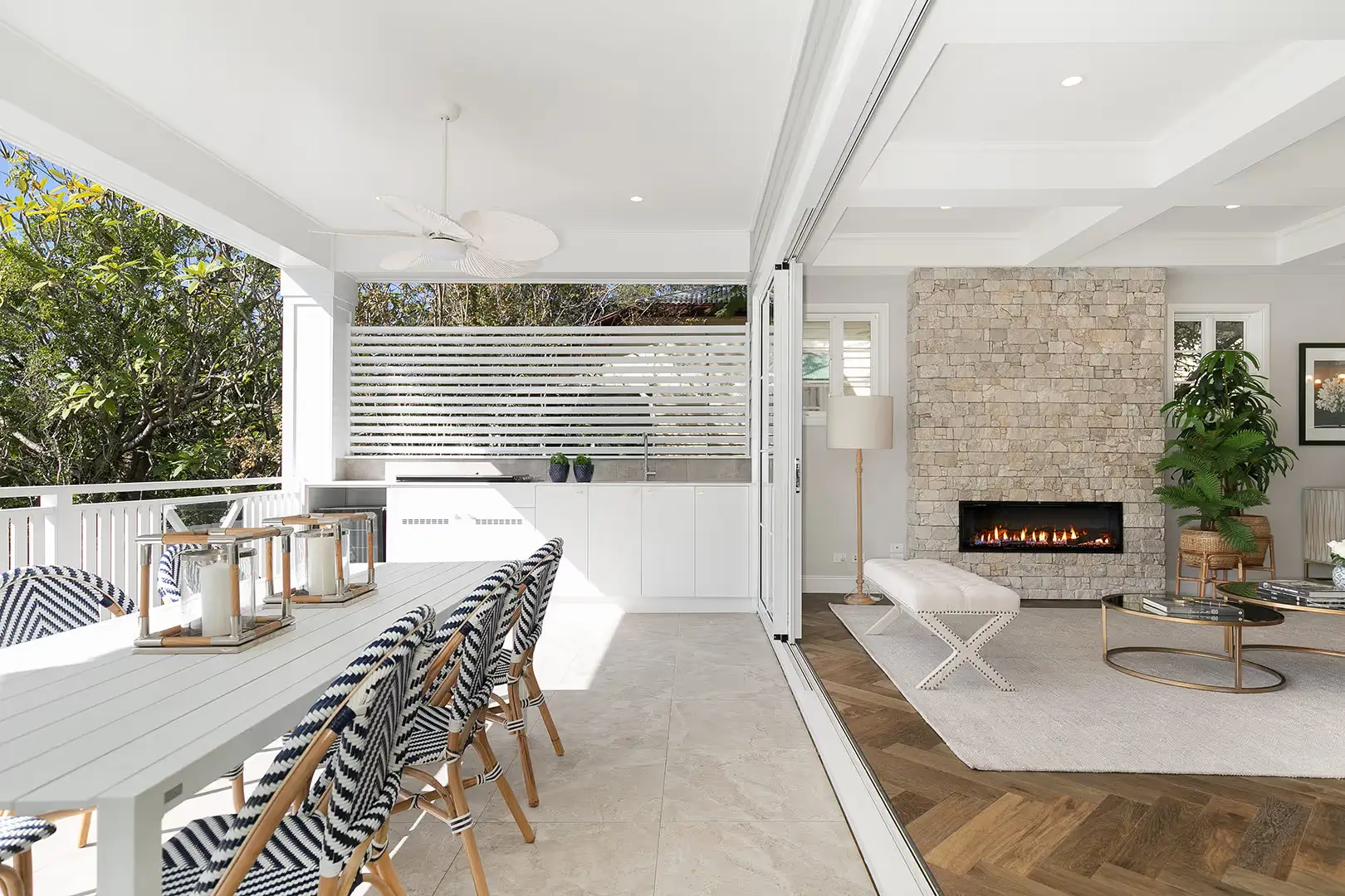 An outdoor entertaining area on the balcony with a dining table and a fan