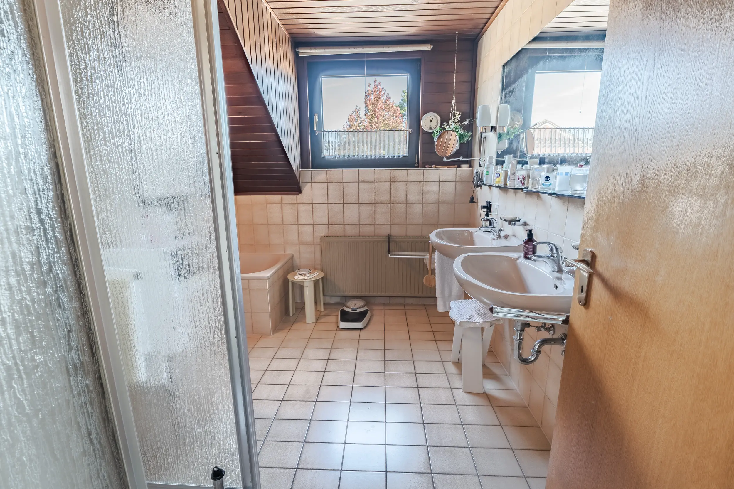 Badezimmer im Dachgeschoss der Doppelhaushälfte in Gronau mit zwei einzelnen Waschbecken, Badewanne und Dusche