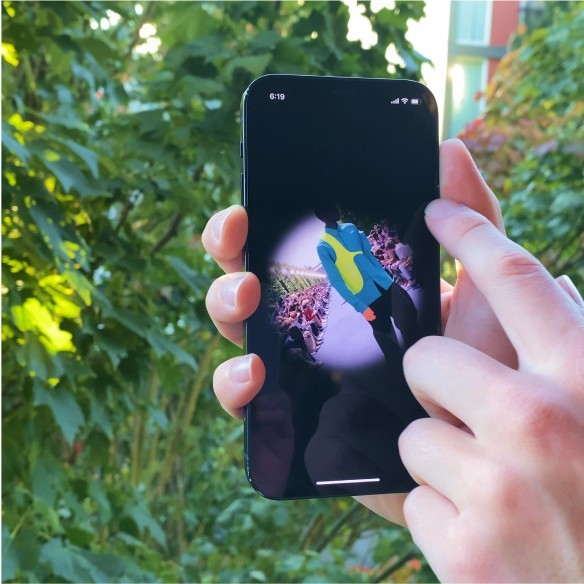 A photo of a phone with a circle image and a green background of leaves