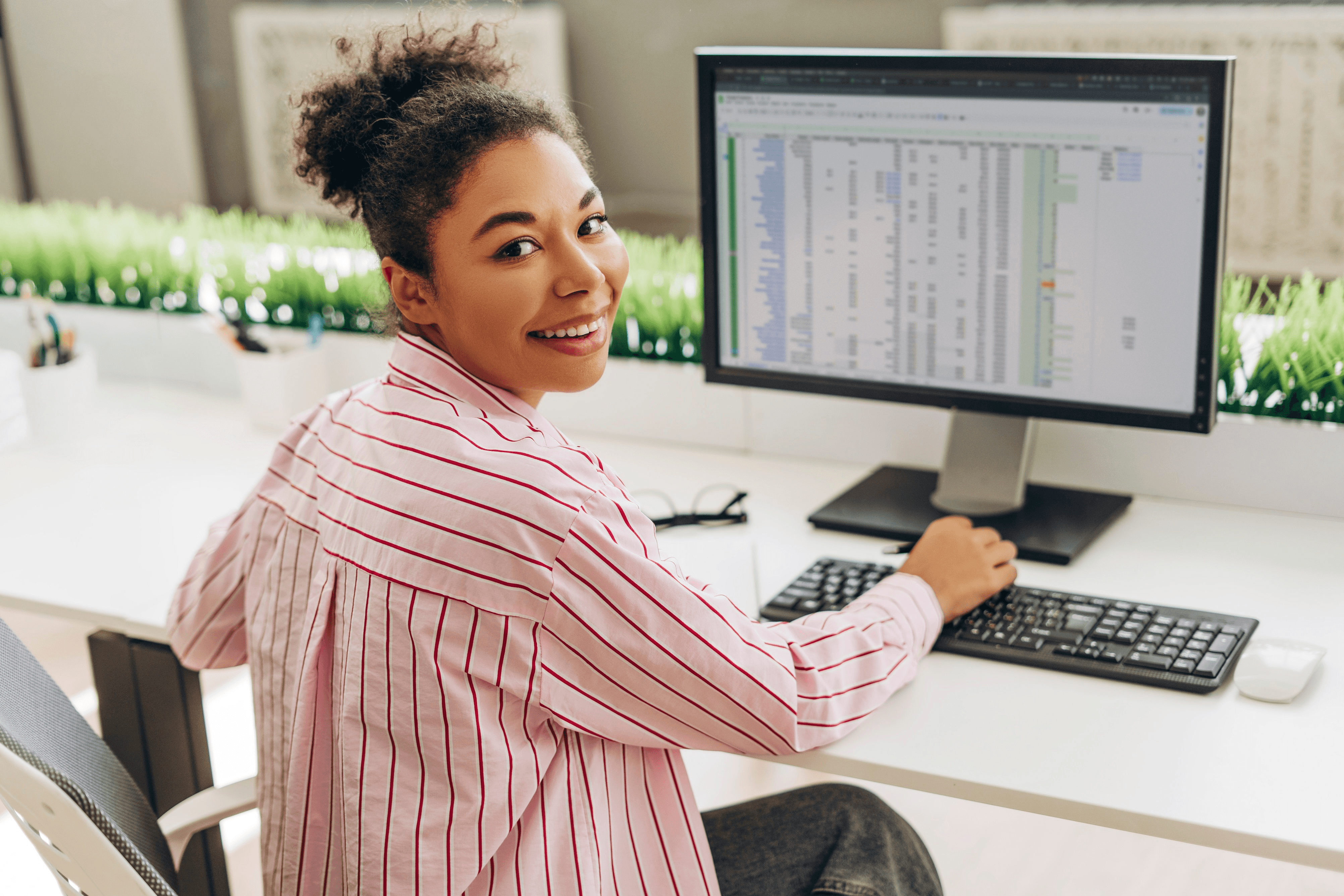 Smiling woman using a computer spreadsheet - How to Use Excel for Finance