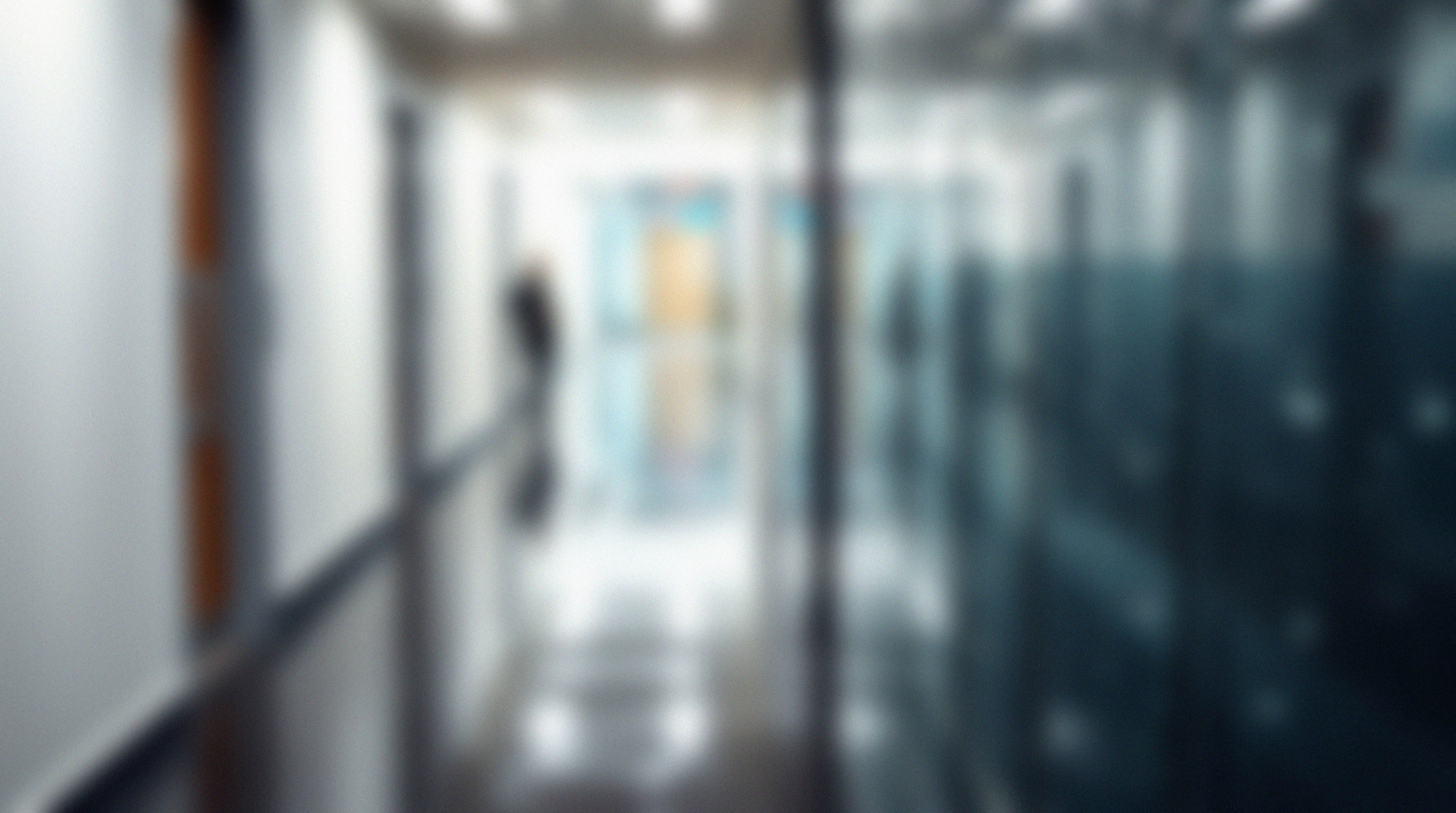A desk with a computer, keyboard, mouse, and calendar in front of a large window with a city view.