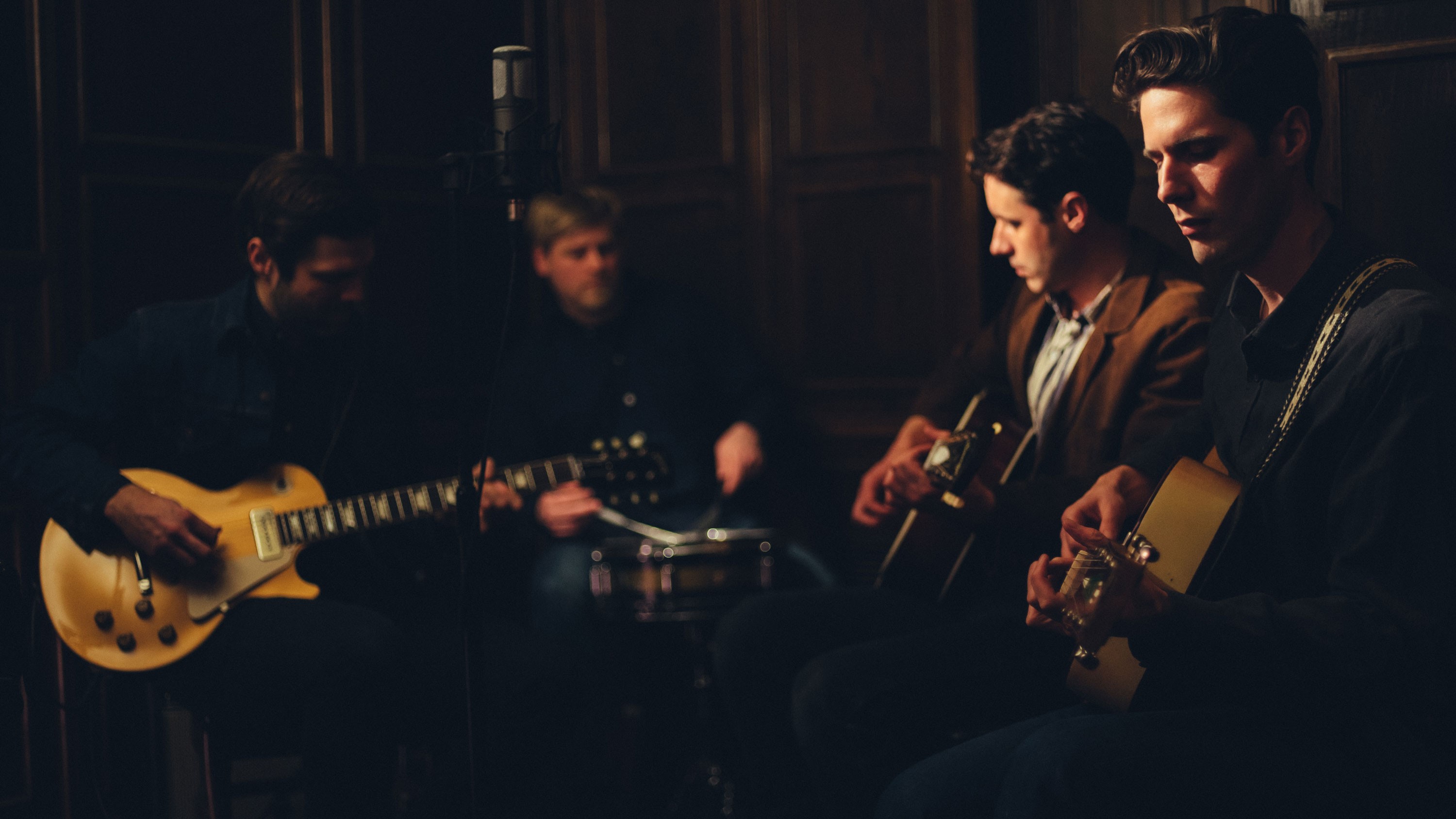 An accounstic band playing in a wooden clad room