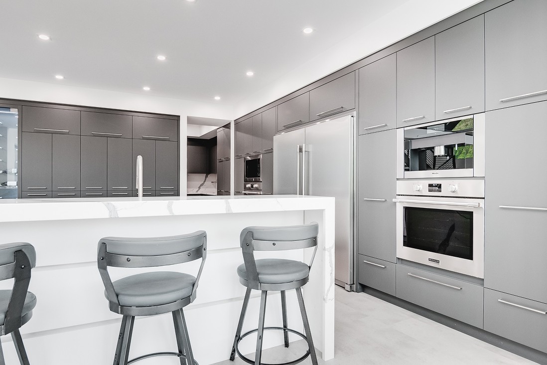 Back view of white island and bar seating in open kitchen