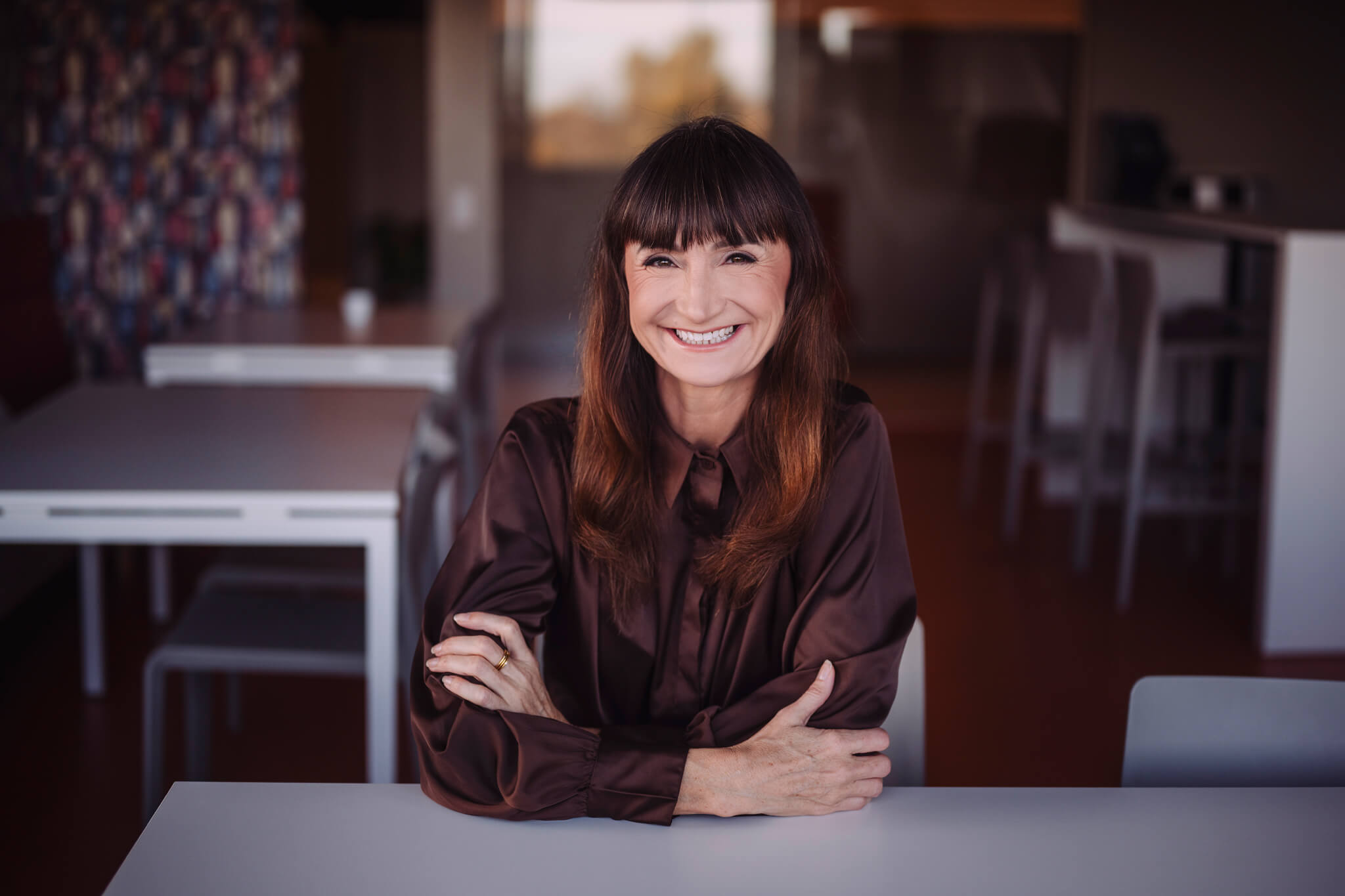 Juhtimiscoach Marika Raiski istub naeratades laua ääres kaasaegses kontoriruumis.