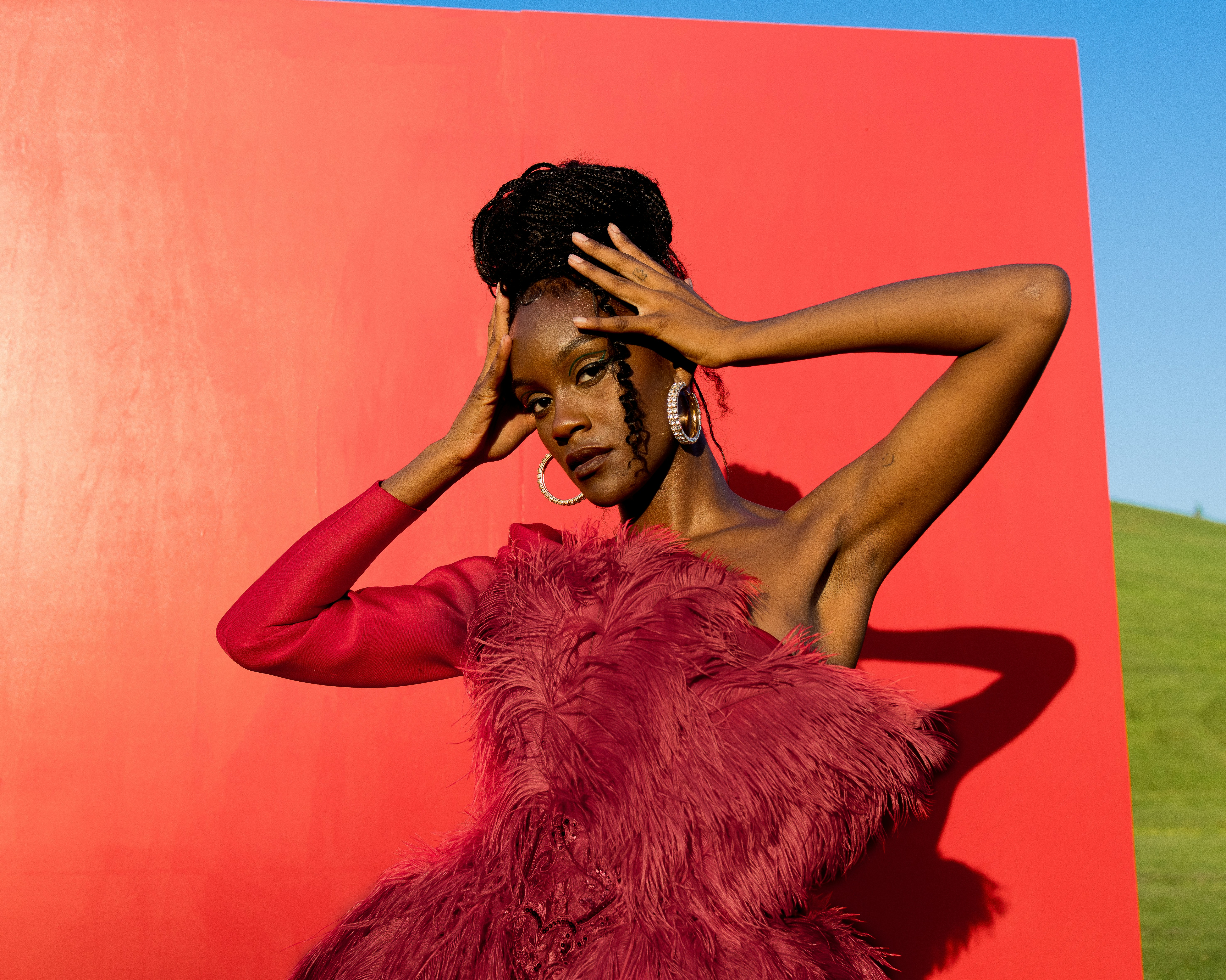 Woman poses elegantly on a white cylinder.