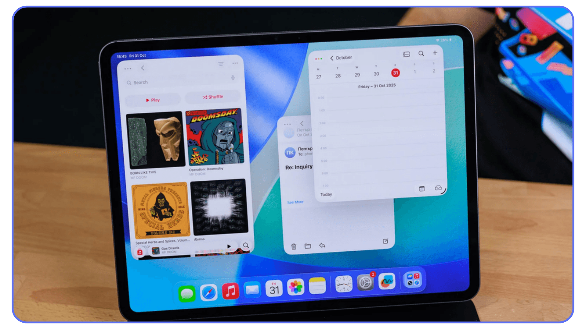 iPad showing multitasking mode with Apple Music, Calendar, and Mail apps open side by side on a wooden desk.