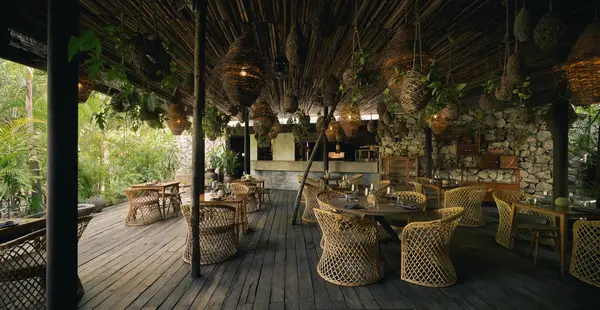 Restaurante Ocumare: Vista interior que muestra mesas y sillas para comensales, con lámparas colgantes y una barra al fondo.