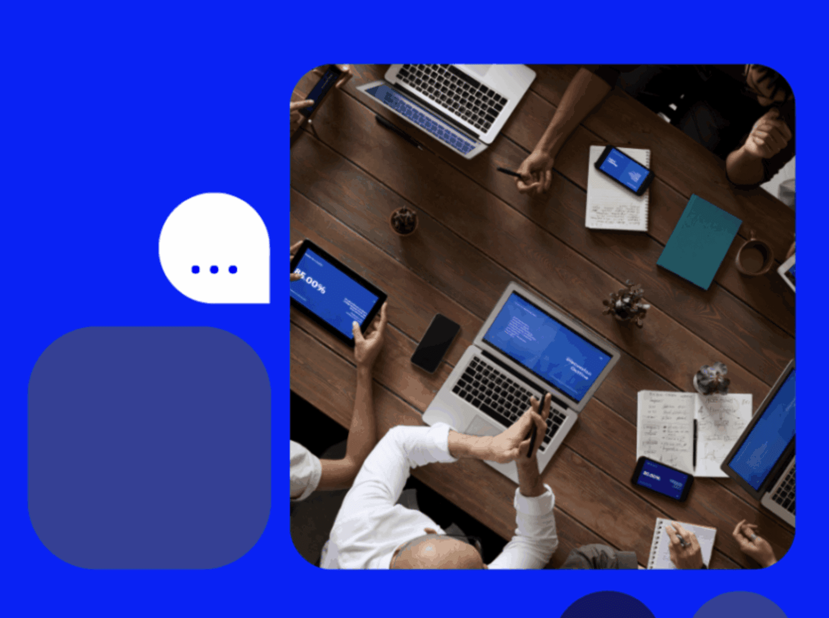 An aerial view of a table surrounded by busy office staff working on their laptops