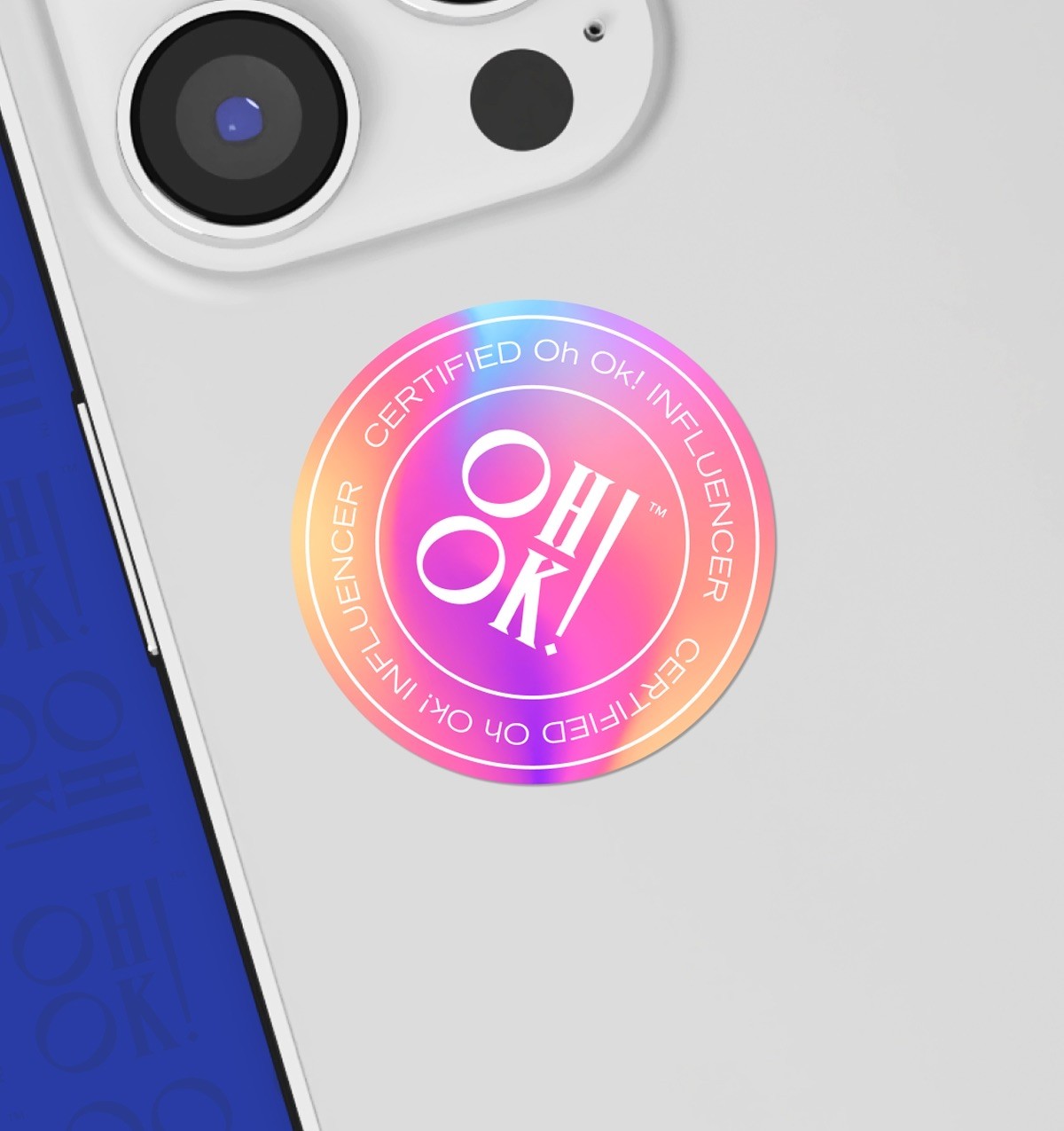 An Oh Ok! Certified Influencer sticker on the back on an iPhone.