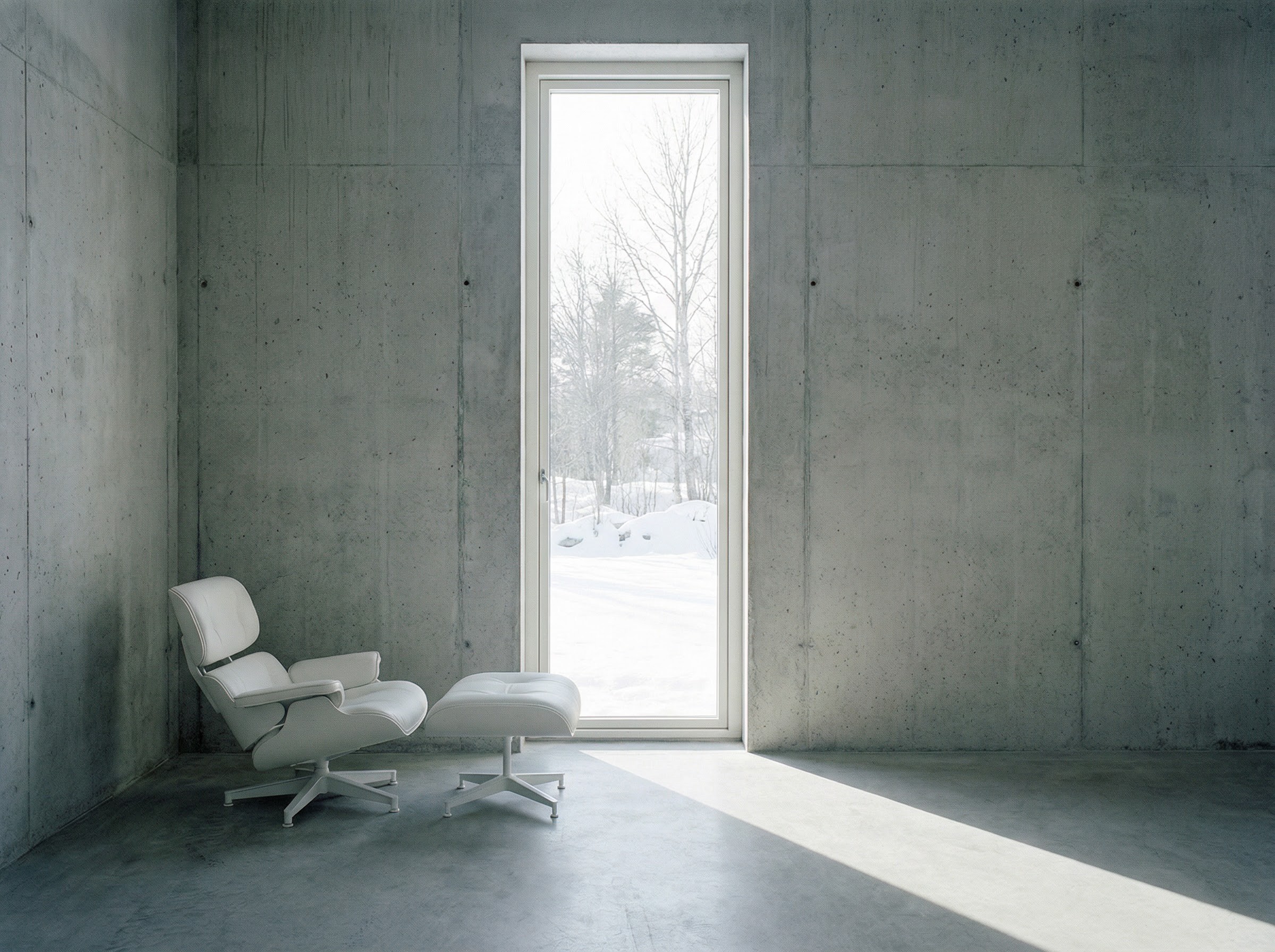 White lounge chair and ottoman in concrete room