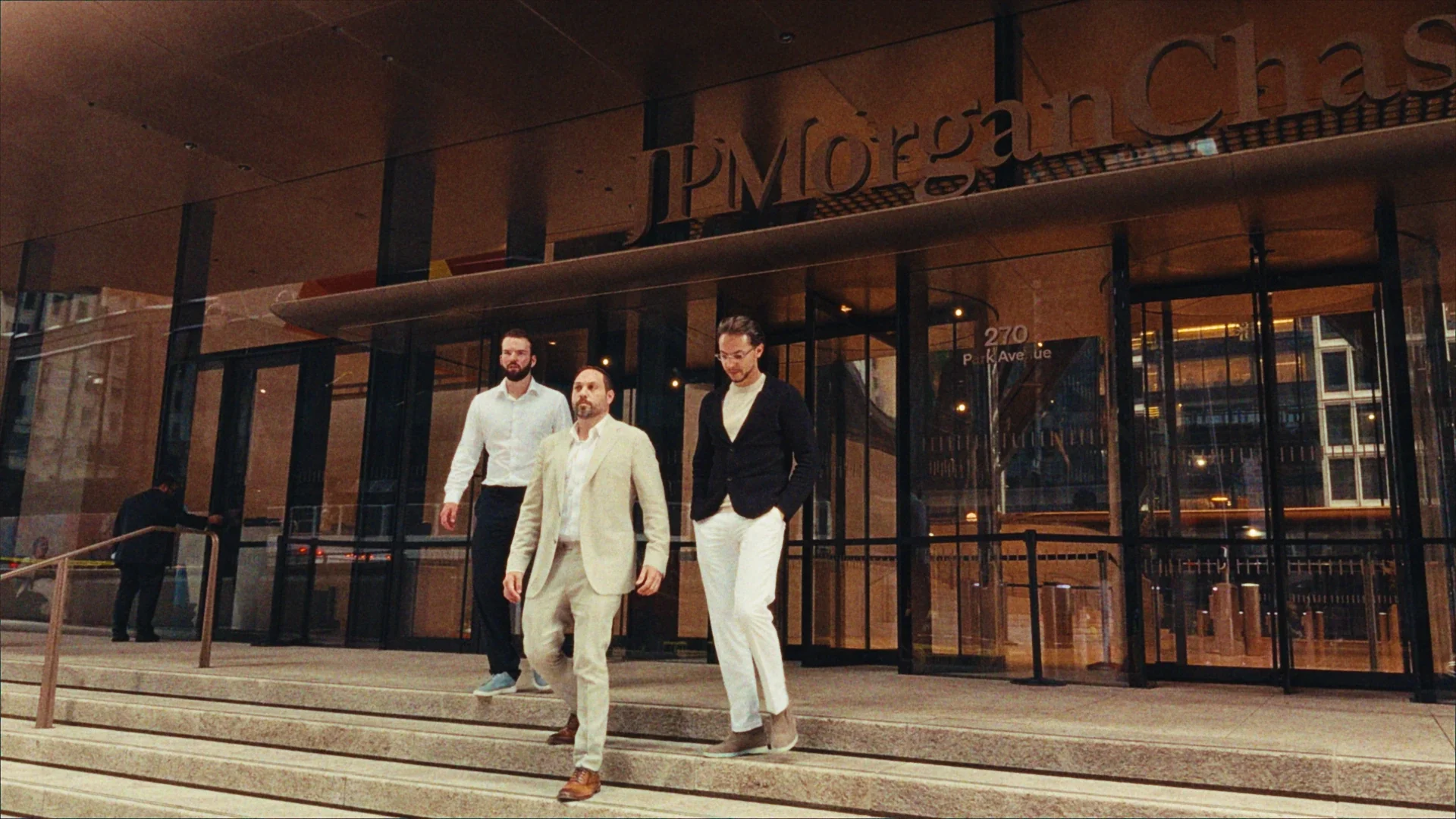 Three men walking out of a JPMorgan Chase building