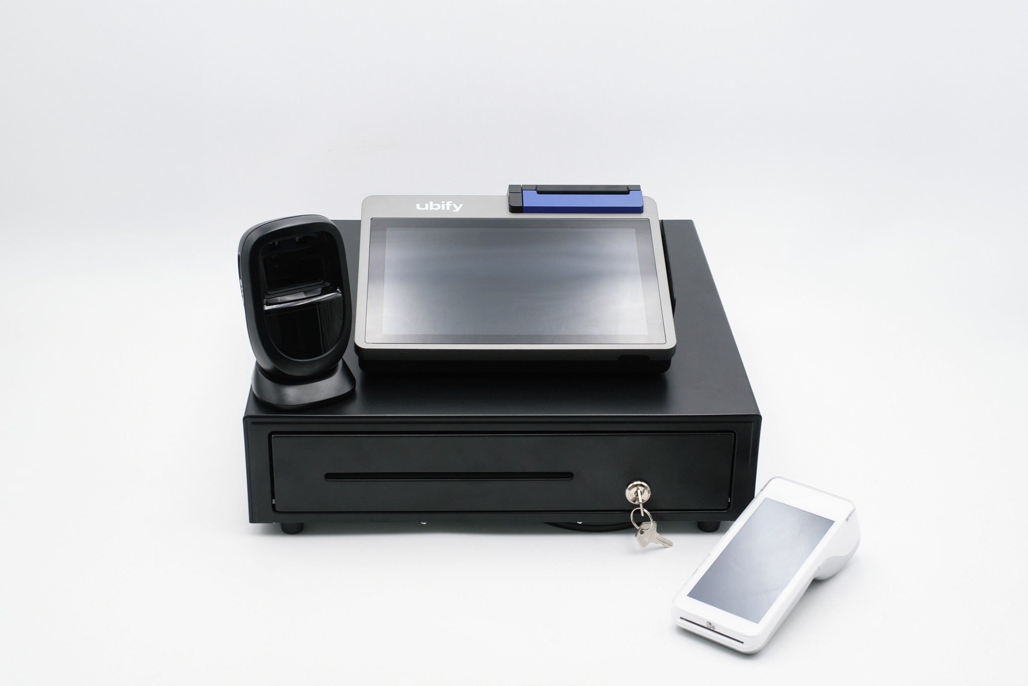 Sistema completo Ubify con cassa touchscreen, lettore barcode, cassetto porta contanti e POS su sfondo bianco.