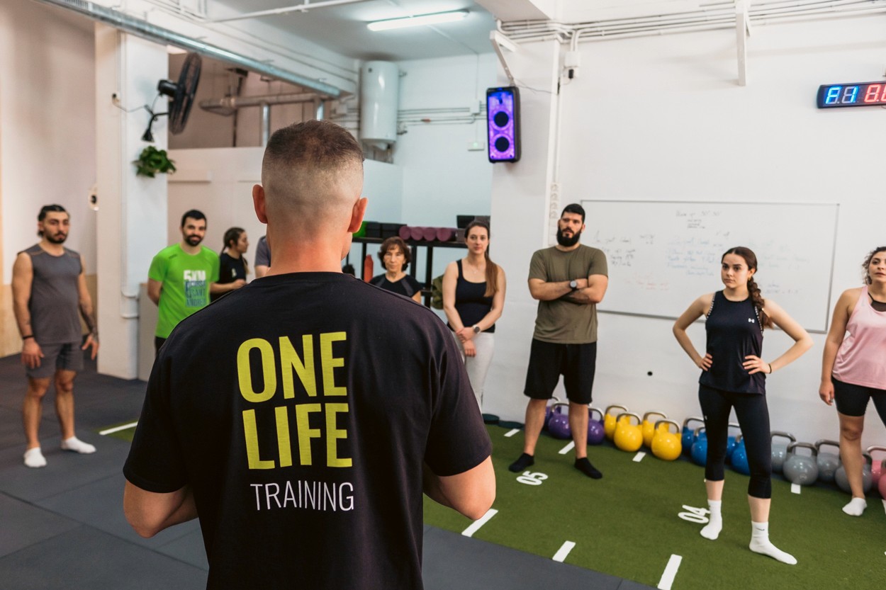 Entrenador de One Life explicant una sessió funcional en grup a Gràcia, Barcelona.