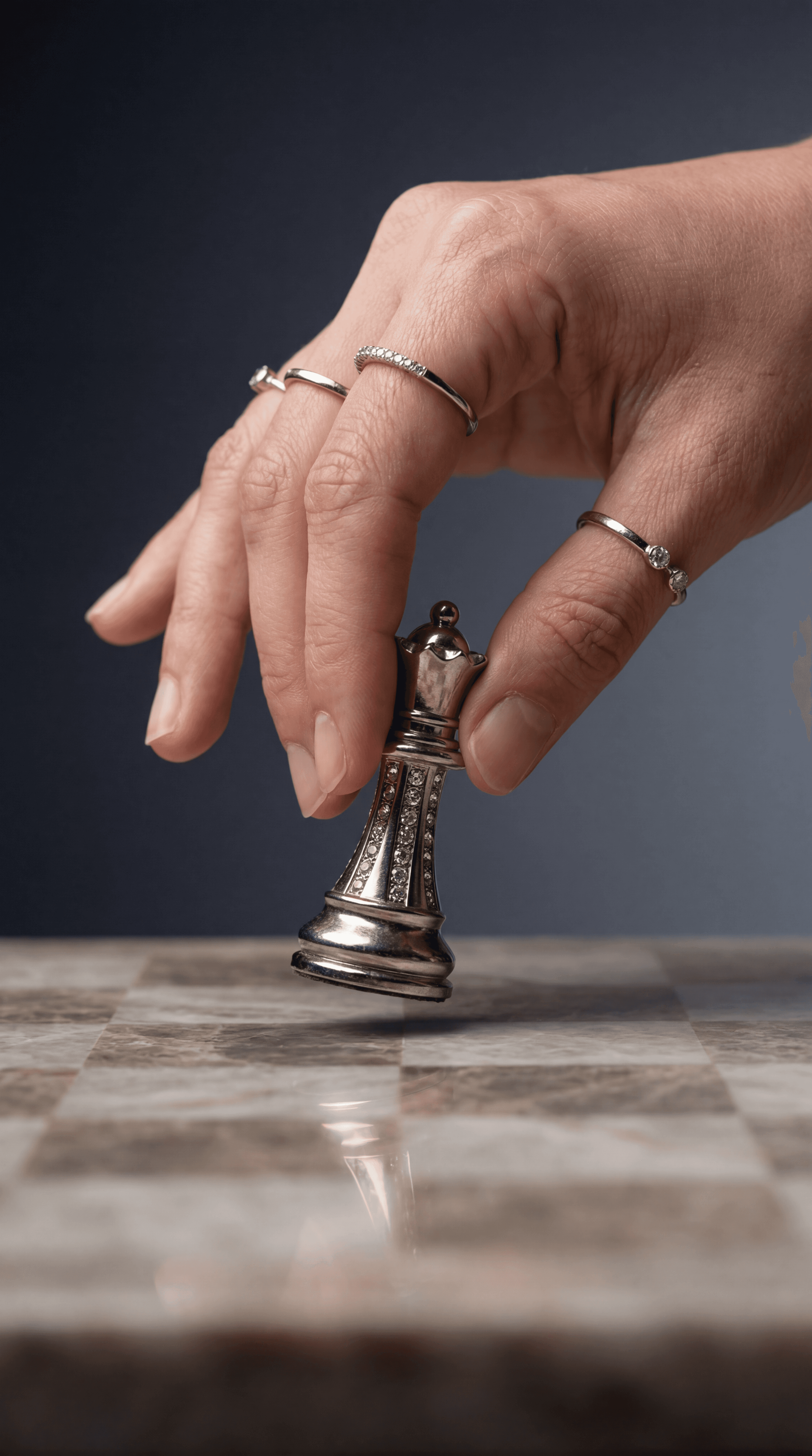 Minimal silver rings and chess piece concept on marble board for jewelry editorial