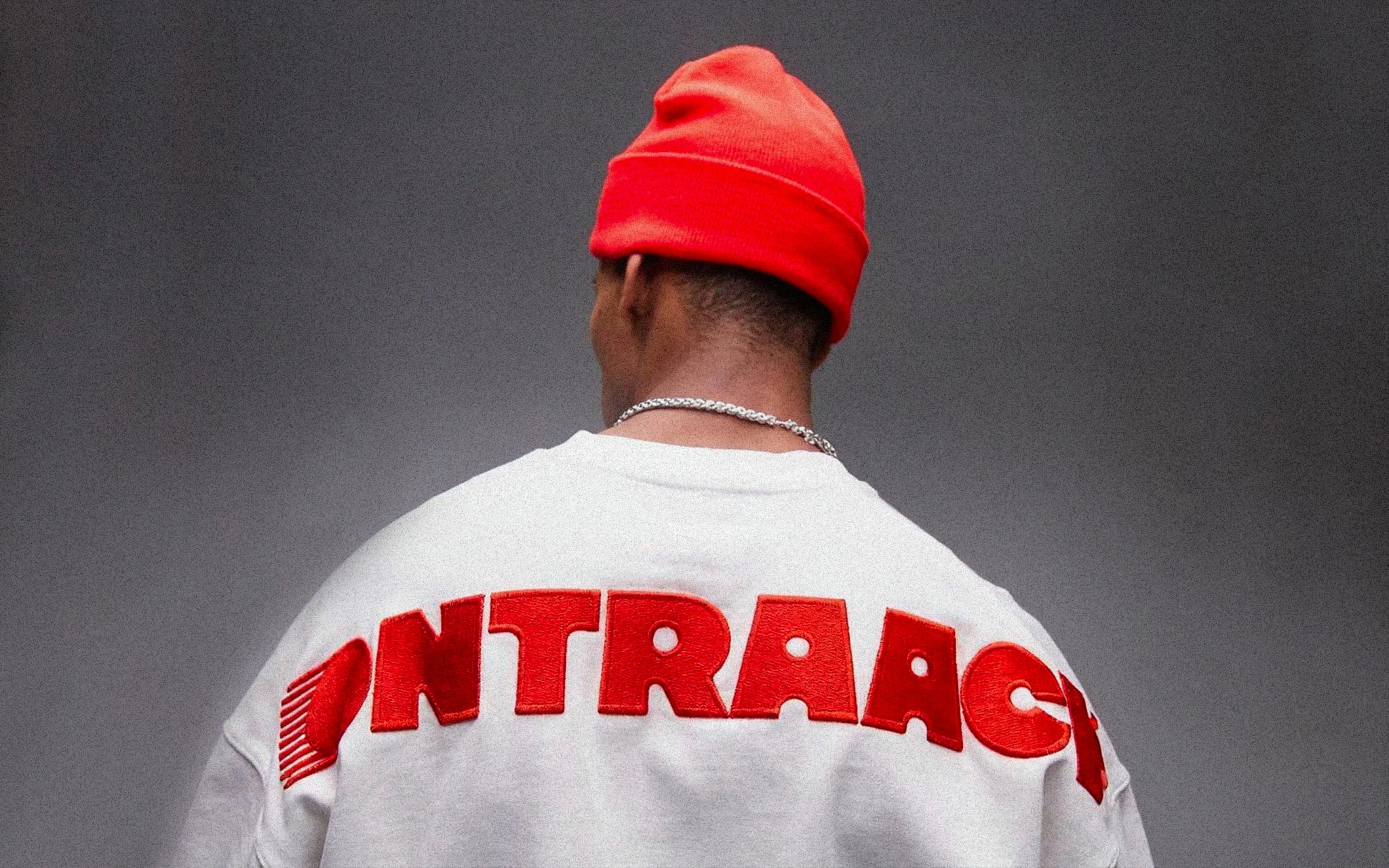 homme de dos portant un sweat avec ontraack brodé dessus en rouge