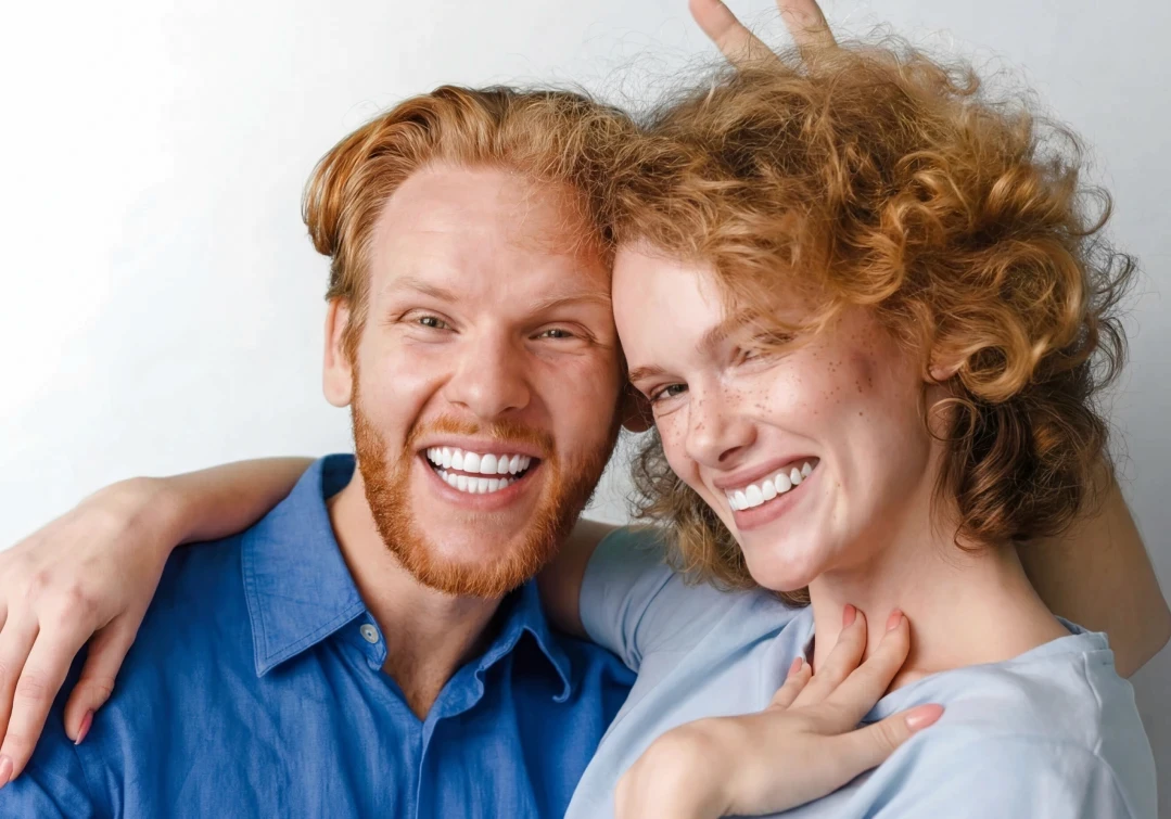 Kobieta z uśmiechem prezentująca efekty bondingu na swoich zębach.