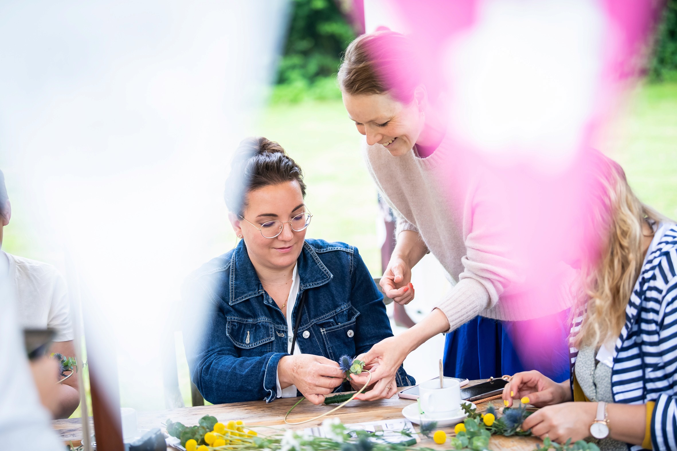 Großes Gruppenfoto von Teilnehmerinnen des Creator Events GHBA & friends im Garten mit Palmen und Sonnenschirmen.