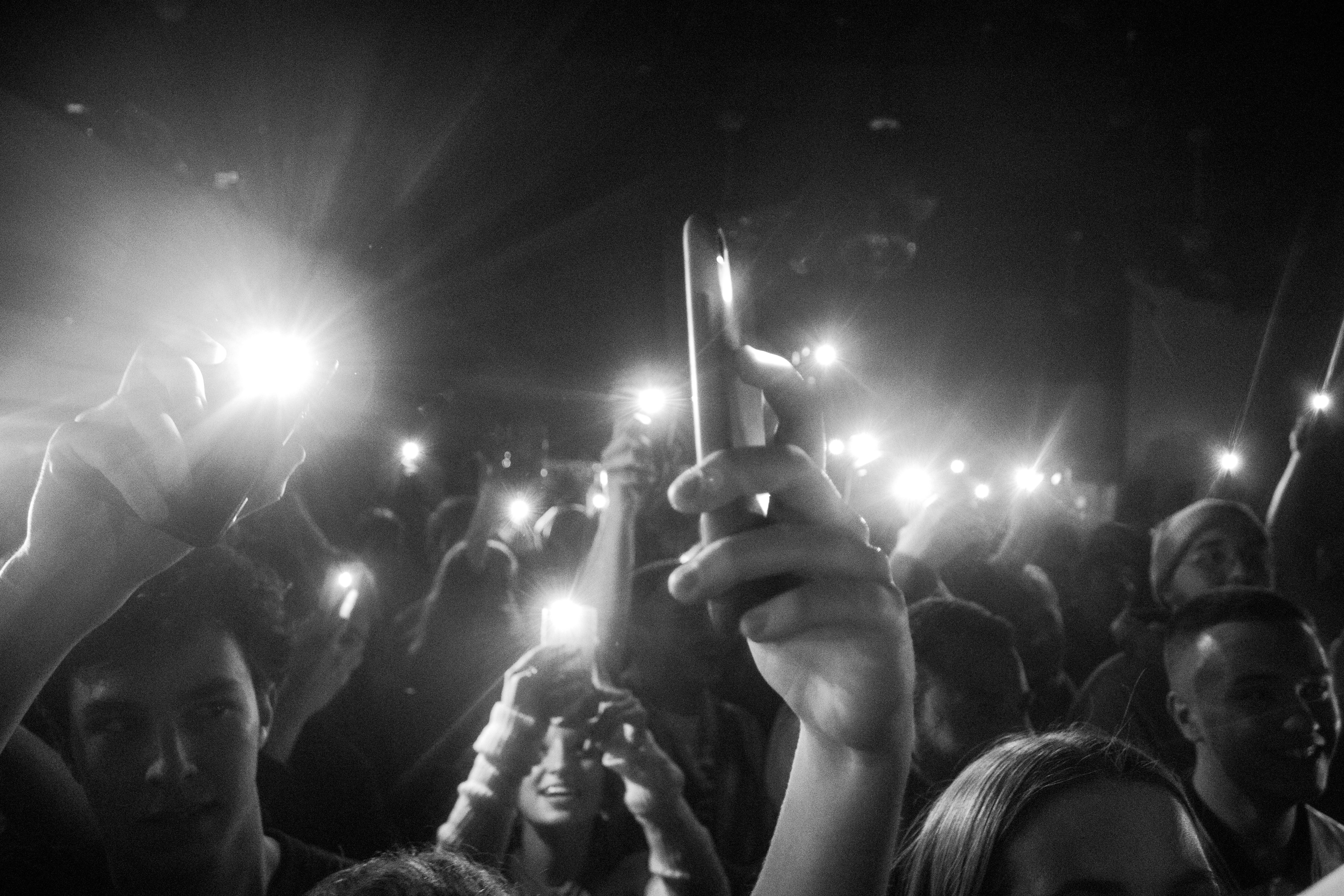 a crowd of people holding up their cell phones