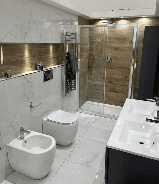 Bagno molto elegante rifinito con rivestimenti in marmo e box doccia in cristallo