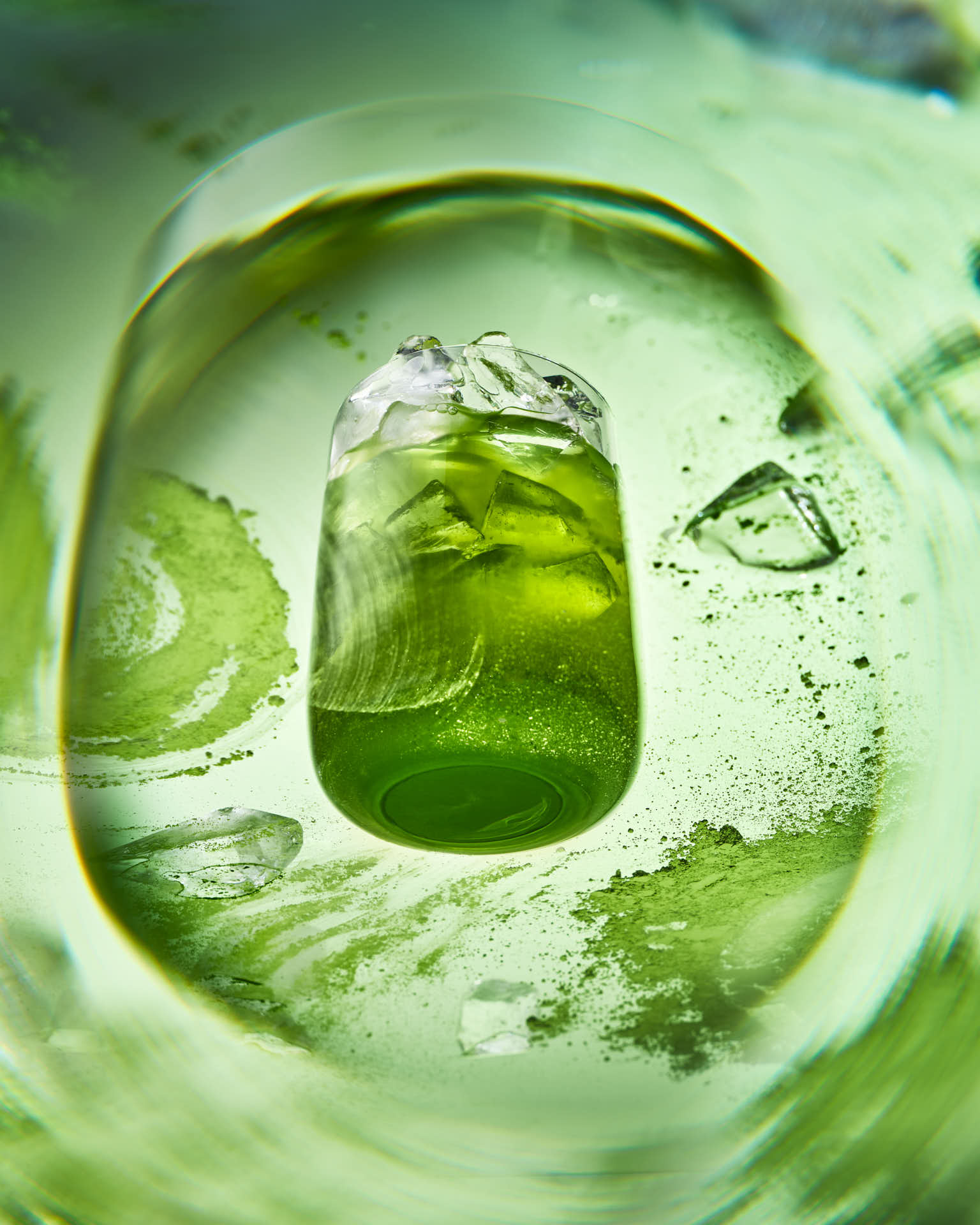 Elegant teal cocktail with floral garnish on luxurious bronze fabric backdrop.