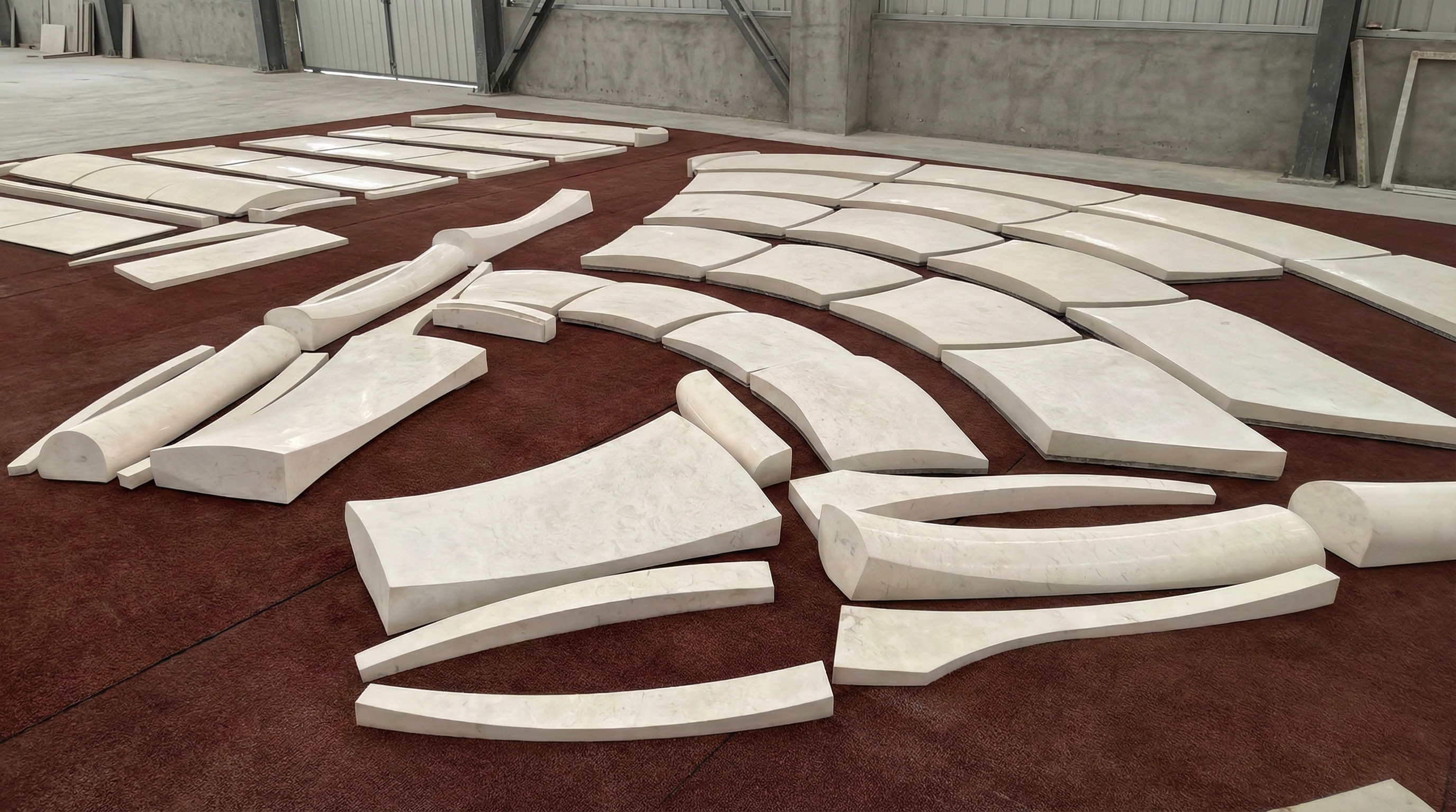 Factory dry-lay inspection of curved marble facade components for quality control by NOVA STONE.
