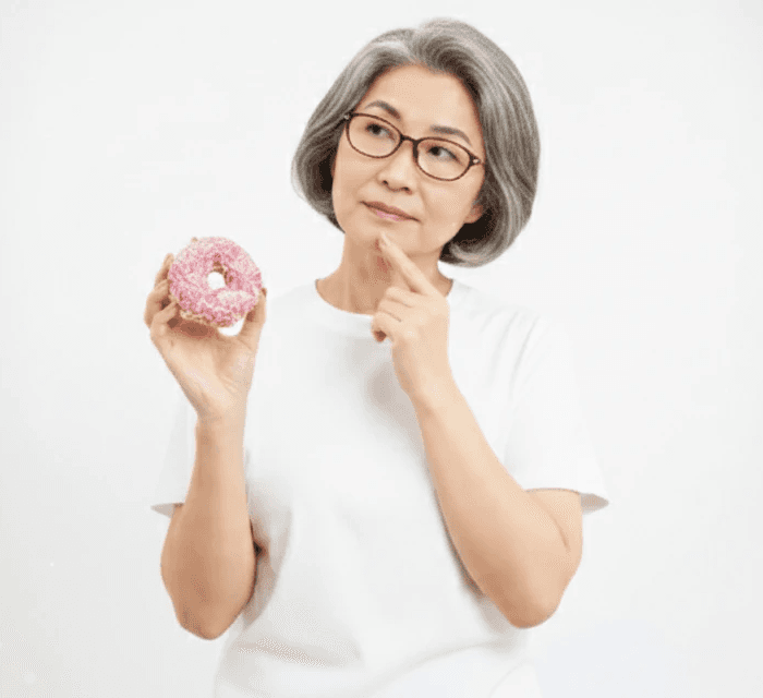 Femme âgée pensive planifiant ses repas et choisissant des aliments fermentés pour diversifier son microbiote dans le cadre du défi #boosttonmicrobiote.