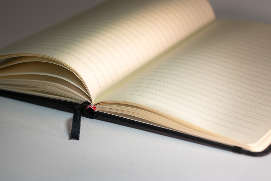 an open notebook with a black ribbon on a table