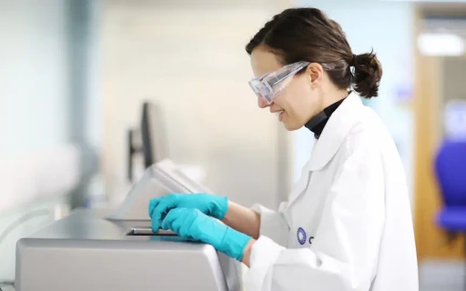 A photo of a lab scienting using a lab machine