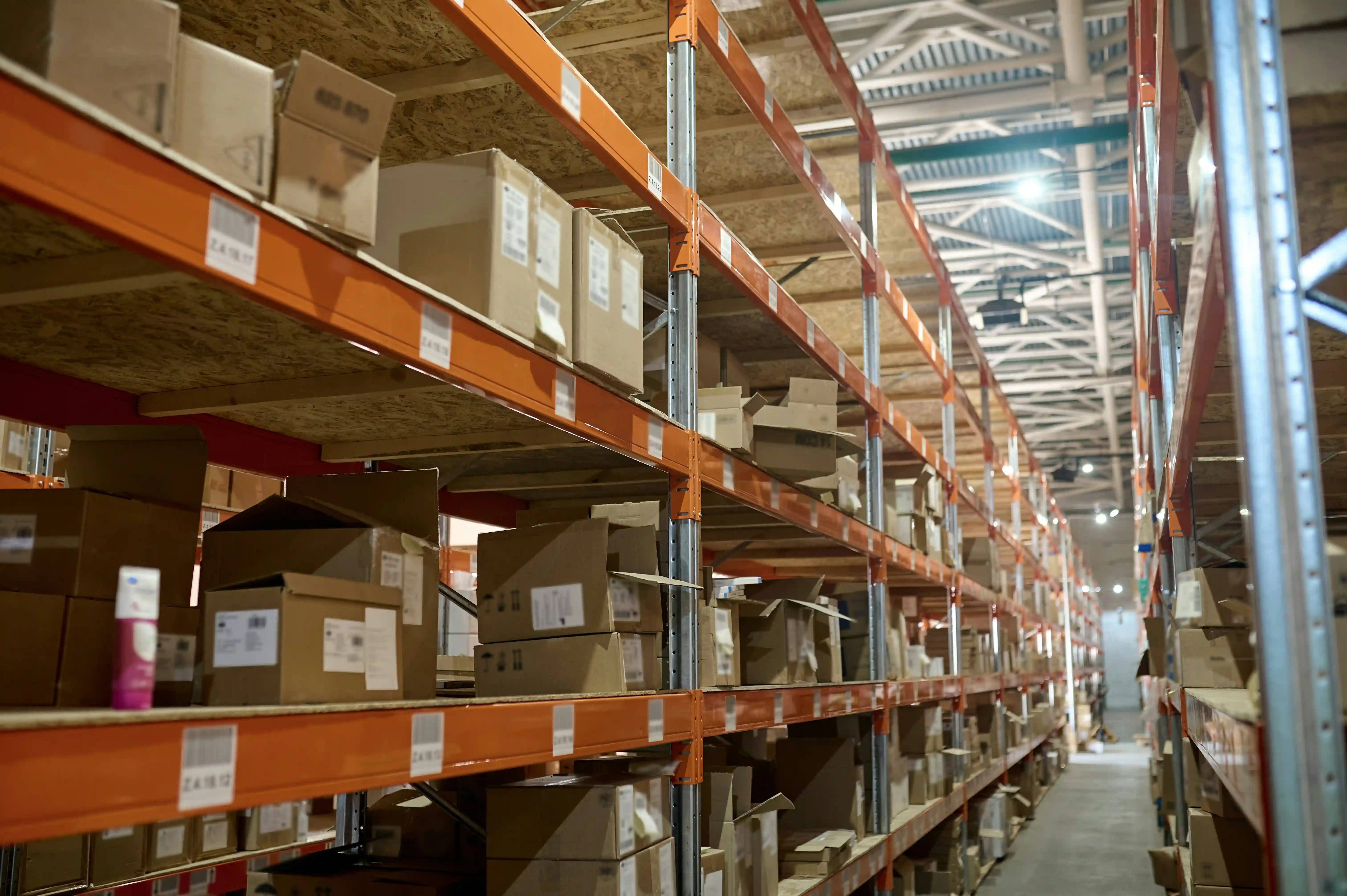 interior shot of a 3PL warehouse with cardboard boxes on orange shelving