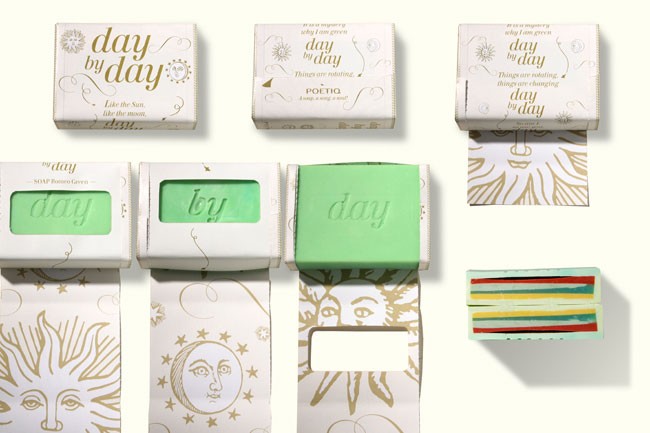 The image displays six boxes of Day by Day soap arranged in two rows of three on a white background. Each box is white with gold text and illustrations. The top row features boxes labeled “day by day” with the tagline “Like the Sun, moon, day,” and “day by day” with the tagline “Things are rotating, things are changing.” The bottom row shows boxes labeled “SOAP Pommero Green” with the tagline “day by day” and a sun and moon design. The boxes contain light green bars of soap.