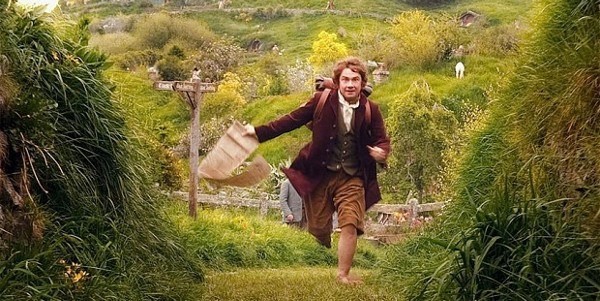Bilbo Baggins running along a green countryside path