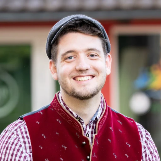 Cornelius Weidmann Webdesign sitzt mit Hemd auf einer Treppe und lächelt