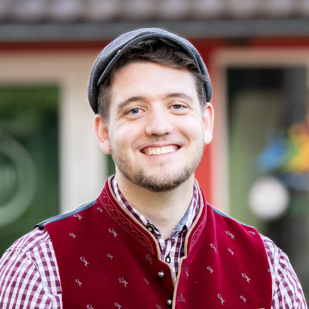 Cornelius Weidmann Webdesign sitzt mit Hemd auf einer Treppe und lächelt