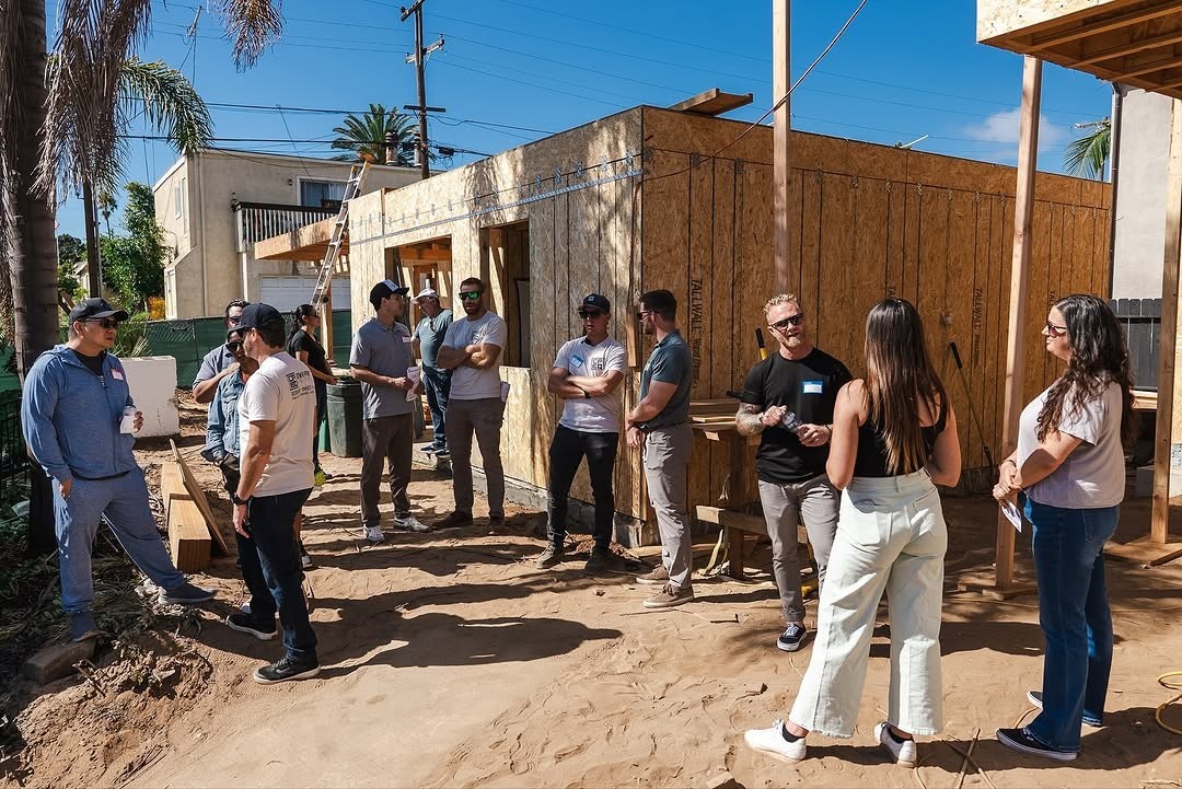 A wooden building sits by a misty lake, with a forest on the opposite shore. The building is reflected in the water.